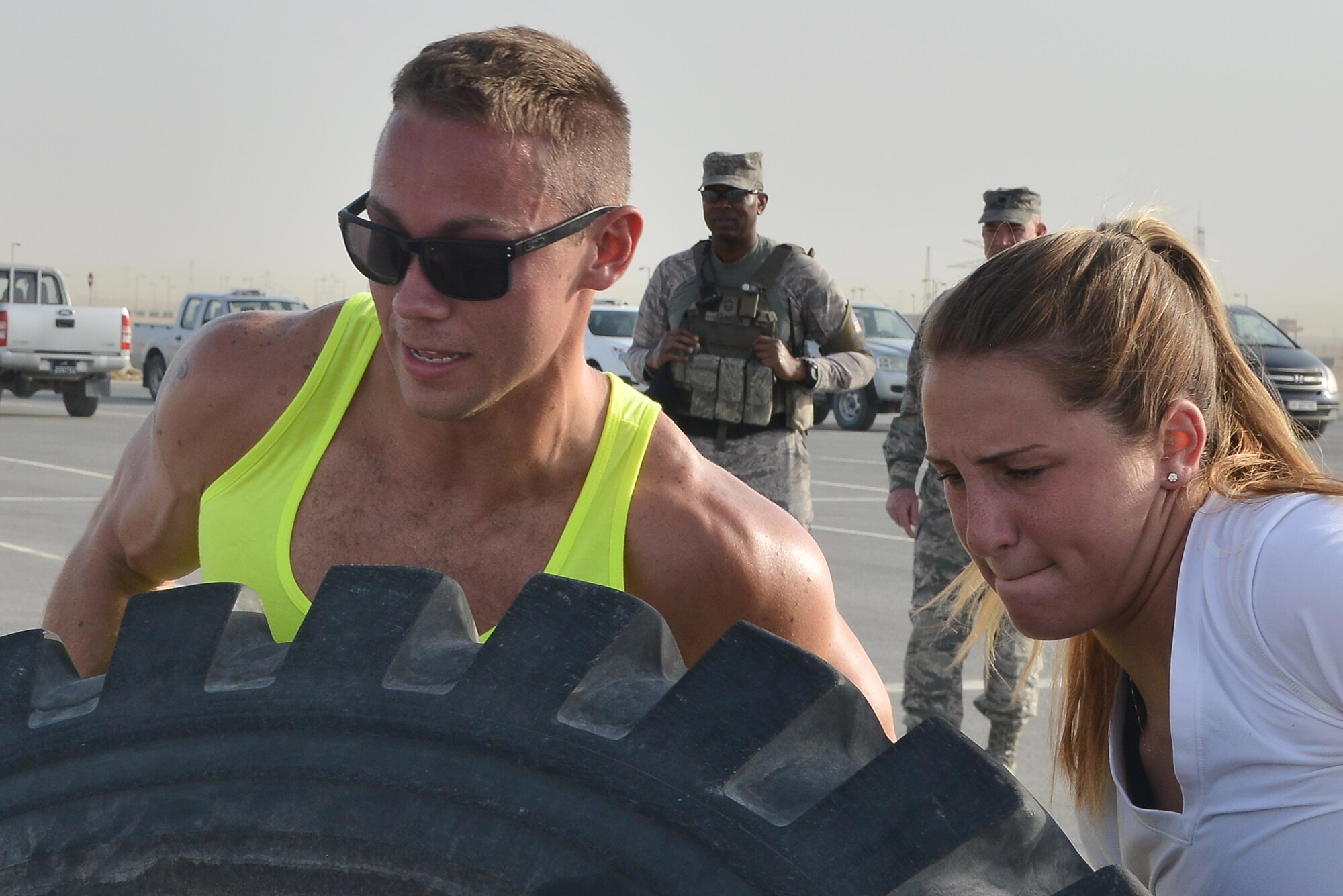 Airman Michael Puckett and Airman 1st Class Kaylyn Nelson, 379th Expeditionary Security Forces Squadron and flip a truck tire as part of a combat challenge for National Police week event May 14, 2015 at Al Udeid Air Base, Qatar. National Police was established to honor American law enforcement in 1962 to help gain recognition to officers that have lost their lives in the line of duty. (U.S. Air Force photo by Staff Sgt. Alexandre Montes)   