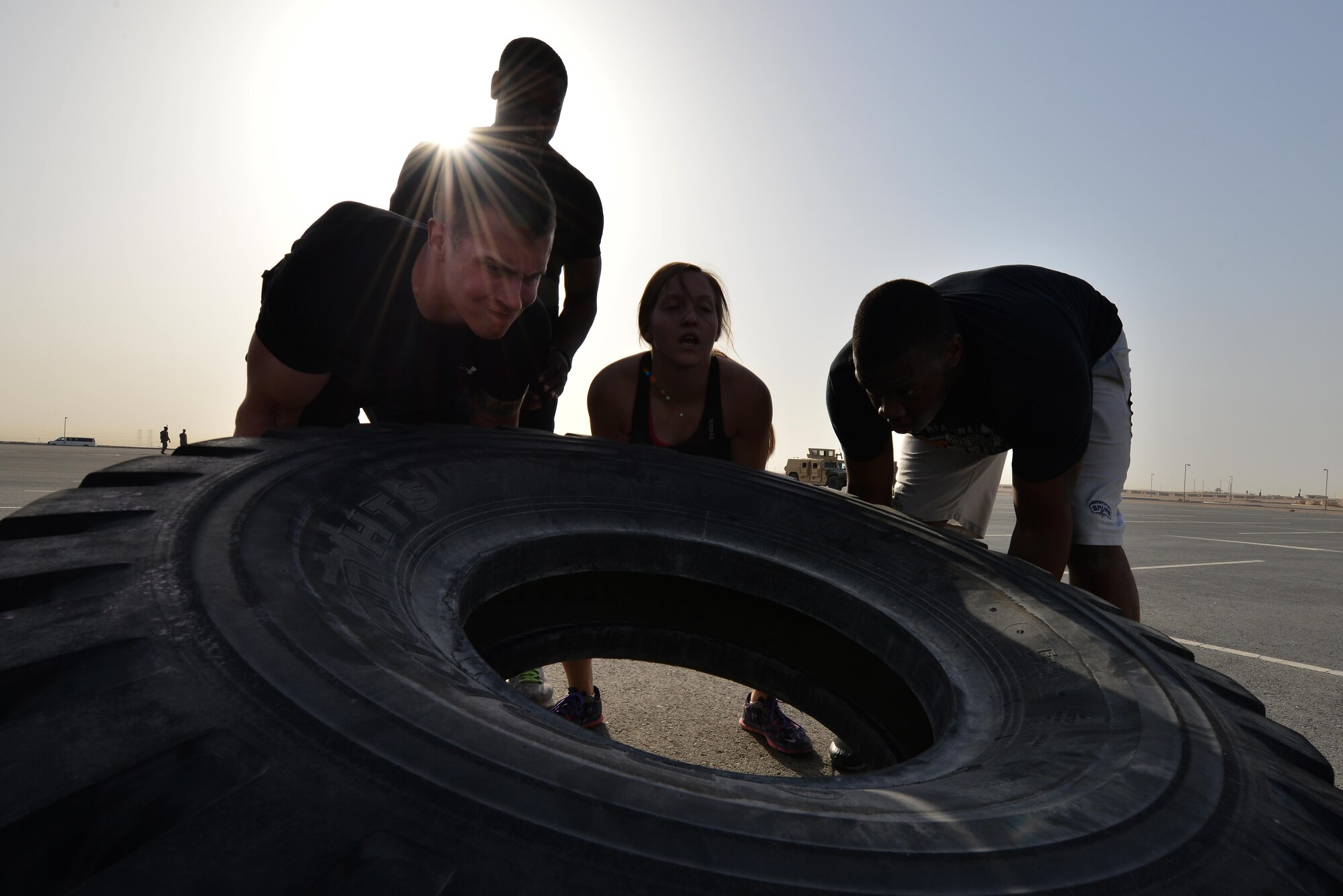 Airmen from the 379th Expeditionary Security Forces Squadron flip a truck tire for a combat challenge as part of National Police week event May 14, 2015 at Al Udeid Air Base, Qatar. National Police was established to honor American law enforcement in 1962 to help gain recognition to officers that have lost their lives in the line of duty. (U.S. Air Force photo by Staff Sgt. Alexandre Montes)   