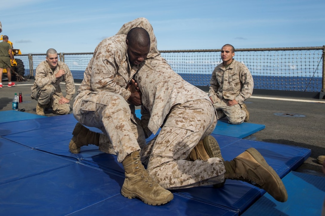U.S. Marine Cpl. Heath Crouch, left, pratices ground fighting techniques with Lance Cpl. Nick Biglione during Marine Corps Martial Arts Program training aboard the USS Rushmore (LSD 47) at sea in the Pacfic Ocean, May 13, 2015. Crouch is an intelligence specialist and Biglione is a rifleman with Kilo Company, Battalion Landing Team 3rd Battalion, 1st Marine Regiment, 15th Marine Expeditionary Unit. MCMAP training helps the Marines maintain a warrior mindset while deployed aboard the ships fo the Essex Amphibious Ready Group. (U.S. Marine Corps photo by Sgt. Emmanuel Ramos/Released)