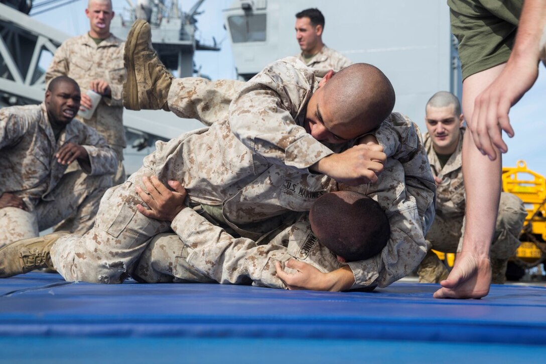U.S. Marine Pfc. Andres Bravo, top, pratices ground fighting techniques with Lance Cpl. Jaime Camacho during Marine Corps Martial Arts Program training aboard the USS Rushmore (LSD 47) at sea in the Pacific Ocean, May 13, 2015. Bravo is a rifleman and Camacho is an automatic rifleman with Kilo Company, Battalion Landing Team 3rd Battalion, 1st Marine Regiment, 15th Marine Expeditionary Unit. MCMAP training helps the Marines maintain a warrior mindset while deployed aboard the ships fo the Essex Amphibious Ready Group. (U.S. Marine Corps photo by Sgt. Emmanuel Ramos/Released)