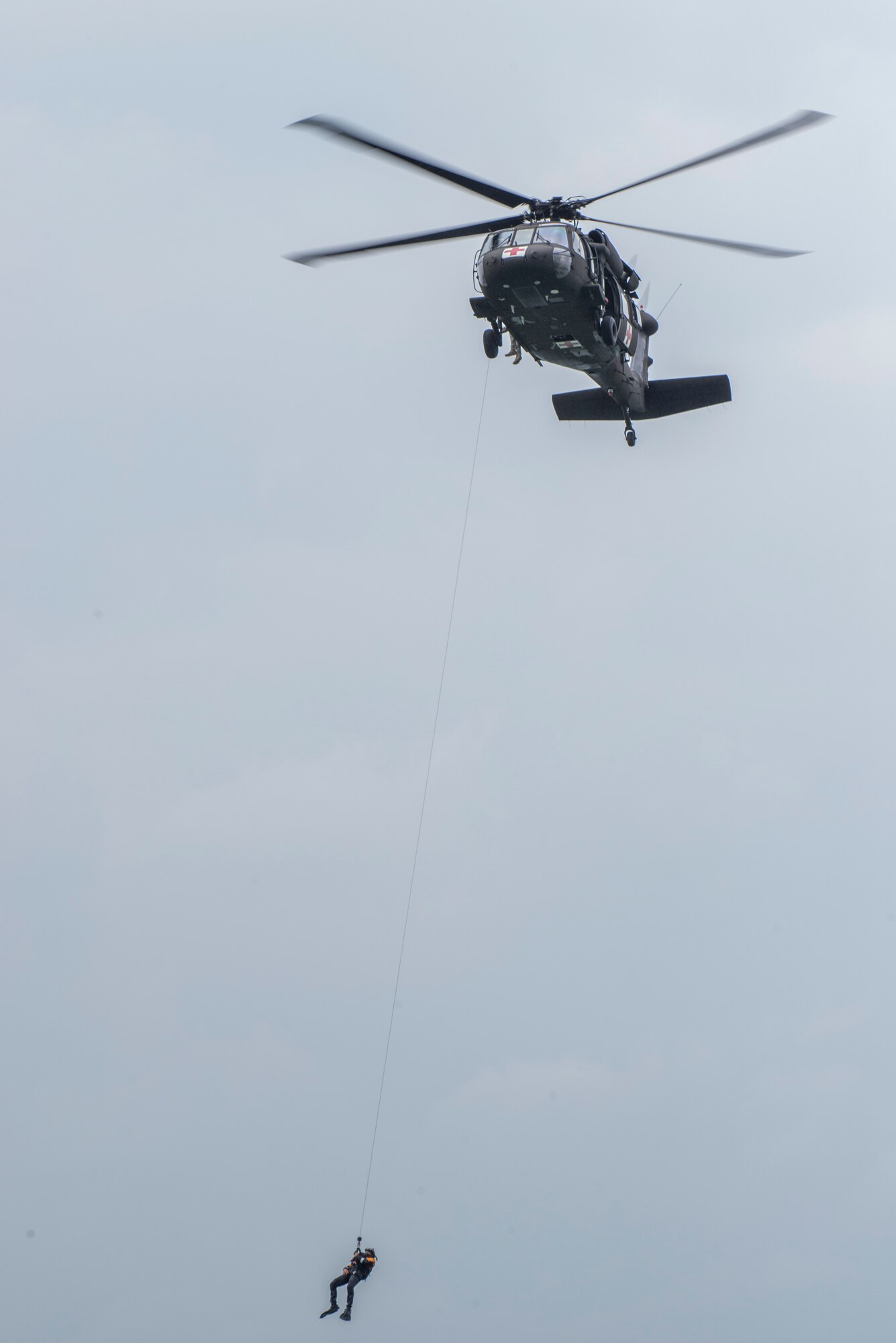 A rescue swimmer is lowered to the water during a helicopter search and rescue training event May 7, 2015, at Canyon Lake, Texas. Members of the 39th Flying Training Squadron, along with the Texas Army National Guard, Texas Task Force 1 and the Texas Parks and Wildlife Department trained together to remain proficient water rescue and survival techniques. (U.S. Air Force photo by Airman 1st Class Stormy Archer)