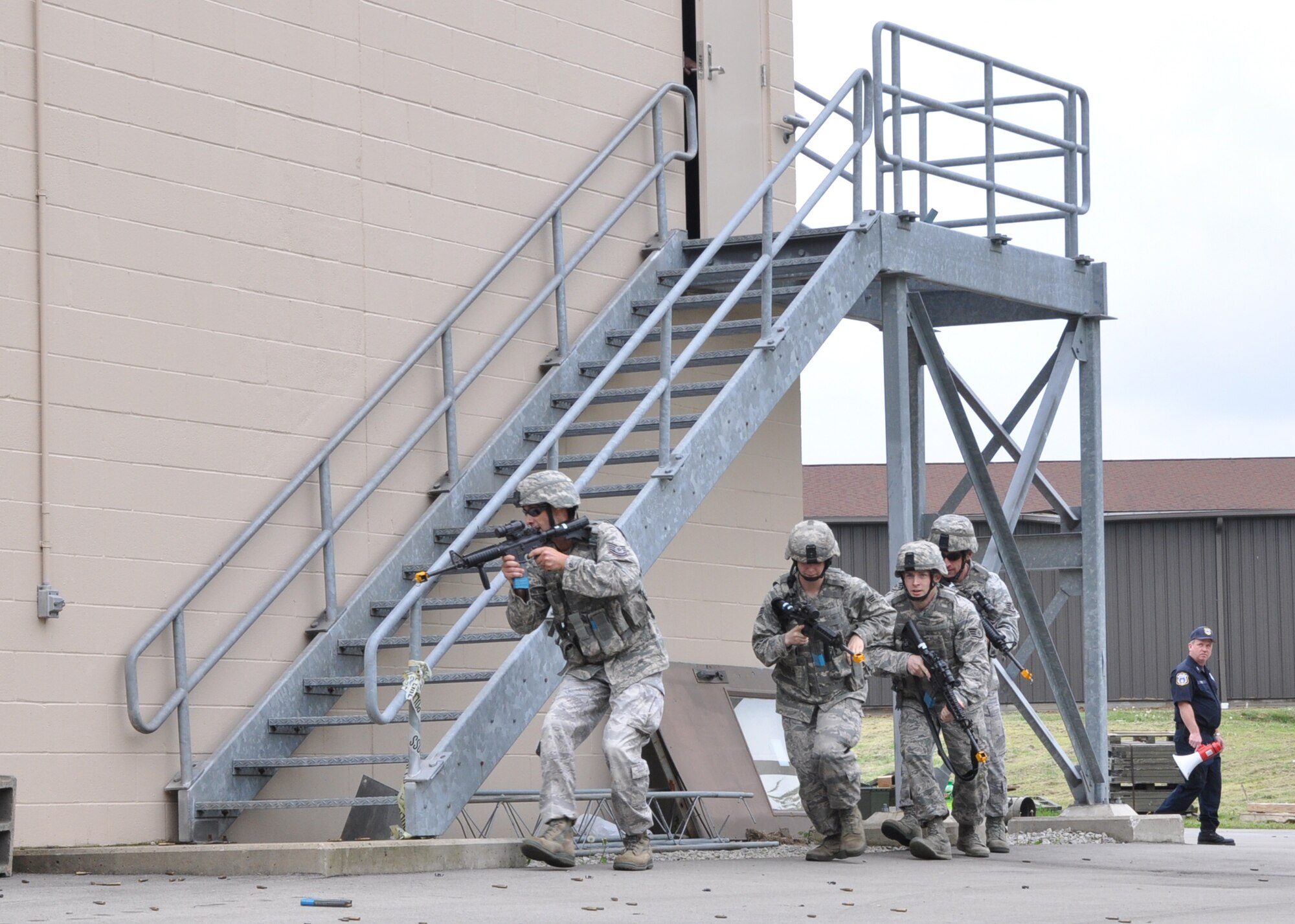 Members of the 910th Security Forces Squadron, forming a fire team, approach an enemy-occupied building during a force-on-force training exercise here, May 16, 2015. Security Forces conducted the exercise to demonstrate their capabilities for approximately 250 Arrowmen here for a Boy Scouts of America Order of the Arrow conclave. During the conclave, the Scouts experienced the military lifestyle through several displays and demonstrations by Youngstown Air Reserve Station Personnel. (U.S. Air Force photo/Chief Master. Sgt. David Prokop)