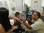 In this file photo, Col. Jeffery Greene, a medical doctor and adolescent pediatrician at Tripler Army Medical Center in Honolulu, Hawaii, does a health screening check for a young child in Palau. Greene is deployed as the primary health provider for a civic action mission on the island of Palau.