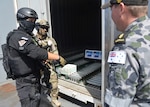 PACIFIC OCEAN (Aug. 6, 2014) A Republic of Korea (ROK) Coastguard and a ROK Navy Sailor question Able Seaman Grahame Kelaher about a mock electronic discharge machine they found in a conex container on USNS Henry J. Kaiser (T-AO 187) during a live exercise for Fortune Guard 2014. Fortune Guard is the region’s premier exercise designed to build regional weapons of mass destruction counter-proliferation capacity and long-term commitment to the proliferation security initiative in the Indo-Asia-Pacific. (U.S. Navy photo by Mass Communication Specialist 1st class Amanda Dunford/Released).