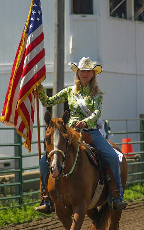Alexis Visser, Pequot Lakes, Minn., resident and avid horse rider, carries the flag during the playing of the “Star Spangled Banner” at the Crow Wing County Fair in 2013. Visser currently works in the 90th Munitions Squadron on F.E. Warren Air Force Base, Wyo. (Courtesy photo)