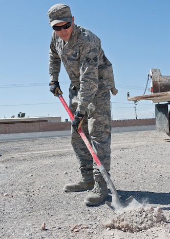 Senior Airman Zachary Costa, 99th Civil Engineer Squadron equipment operator, shovels dirt as part of a “Dirt Boyz” project at Nellis Air Force Base, Nev., May 19. Dirt Boyz are tasked with maintaining runways, sidewalks, roads, signs, crane support and anything related to base maintenance. (U.S. Air Force photo by Airman 1st Class Jake Carter)