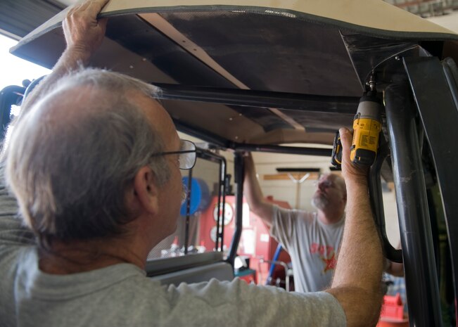 Curtis Klitzka, 547th Intelligence Squadron sheet metal painter, uses a drill to attach a roof to a golf cart at the Threat Training Facility Maintenance Shop on Nellis Air Force Base, Nev., May 14, 2015. The maintenance shop repurposes used equipment for squadrons and units in need. (U.S. Air Force photo by Airman 1st Class Rachel Loftis) 