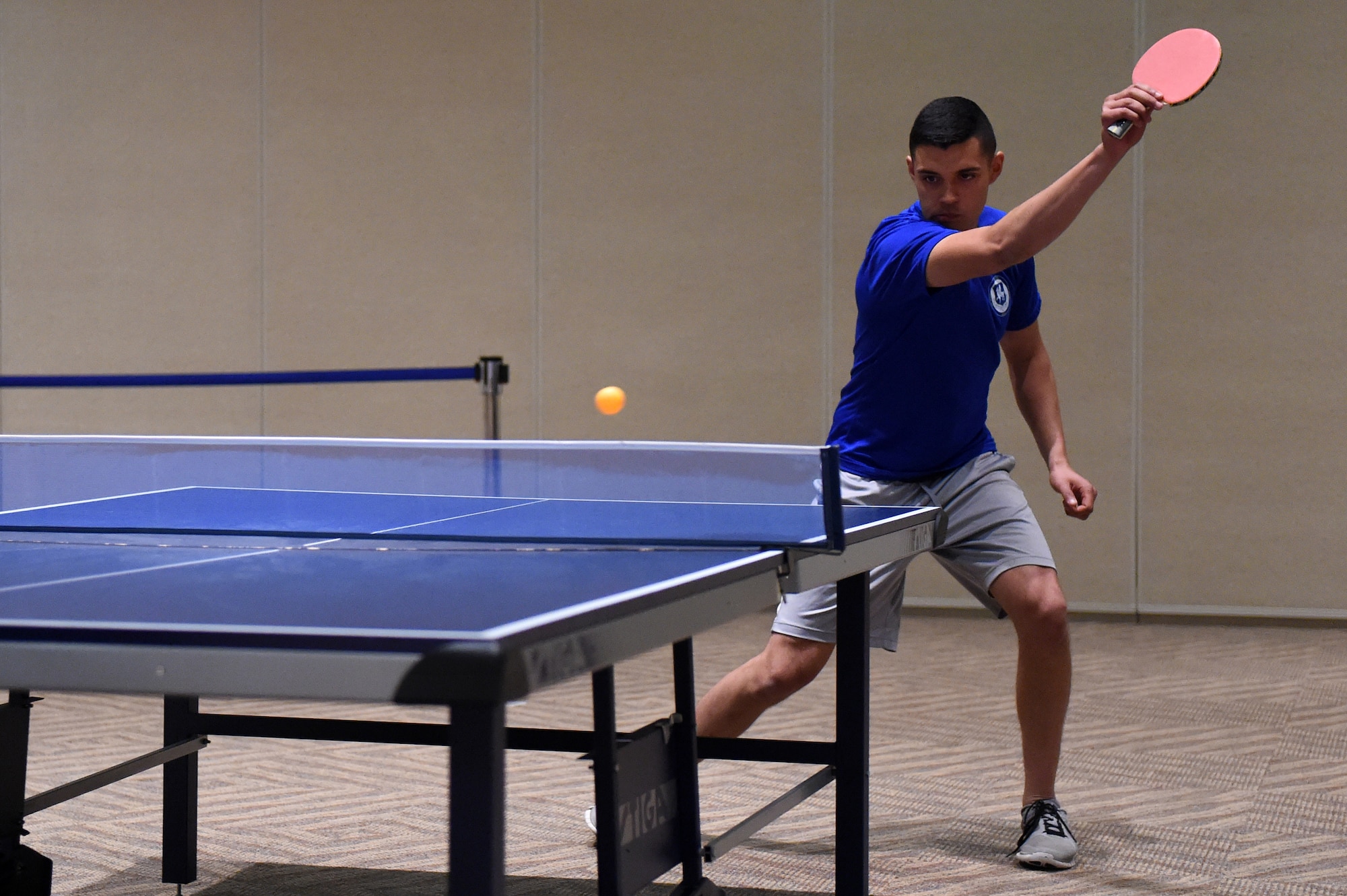 A table tennis player hits the ball during the Tri-Wing Sports Day competition May 20, 2015, on Buckley Air Force Base, Colo. Tri-Wing Sports Day is held once a year between the three Air Force Space Command bases and is intended to promote healthy, active lifestyles and friendly competition. The bases competed against each other in over 15 sports such as volleyball, football, tennis and softball among others. (U.S. Air Force photo by Airman 1st Class Emily E. Amyotte/Released)