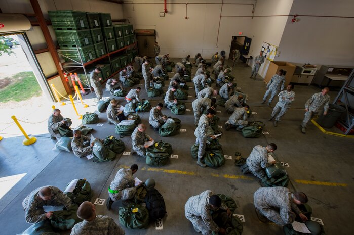 U.S. Air Force Airmen perform mobility bag inventory during Crescent Reach 15 May 2015. This local exercise tested and evaluated Joint Base Charleston's ability to launch a large aircraft formation in addition to process and deploy duty passengers and cargo in response to a simulated crisis abroad May 18-21. Deploying members' ability to survive and operate in deployed environments was also exercised through Chemical, Biological, Radiological, Nuclear Explosives training and evaluation events. (U.S. Air Force photo by Staff Sgt. Jamal D. Sutter)