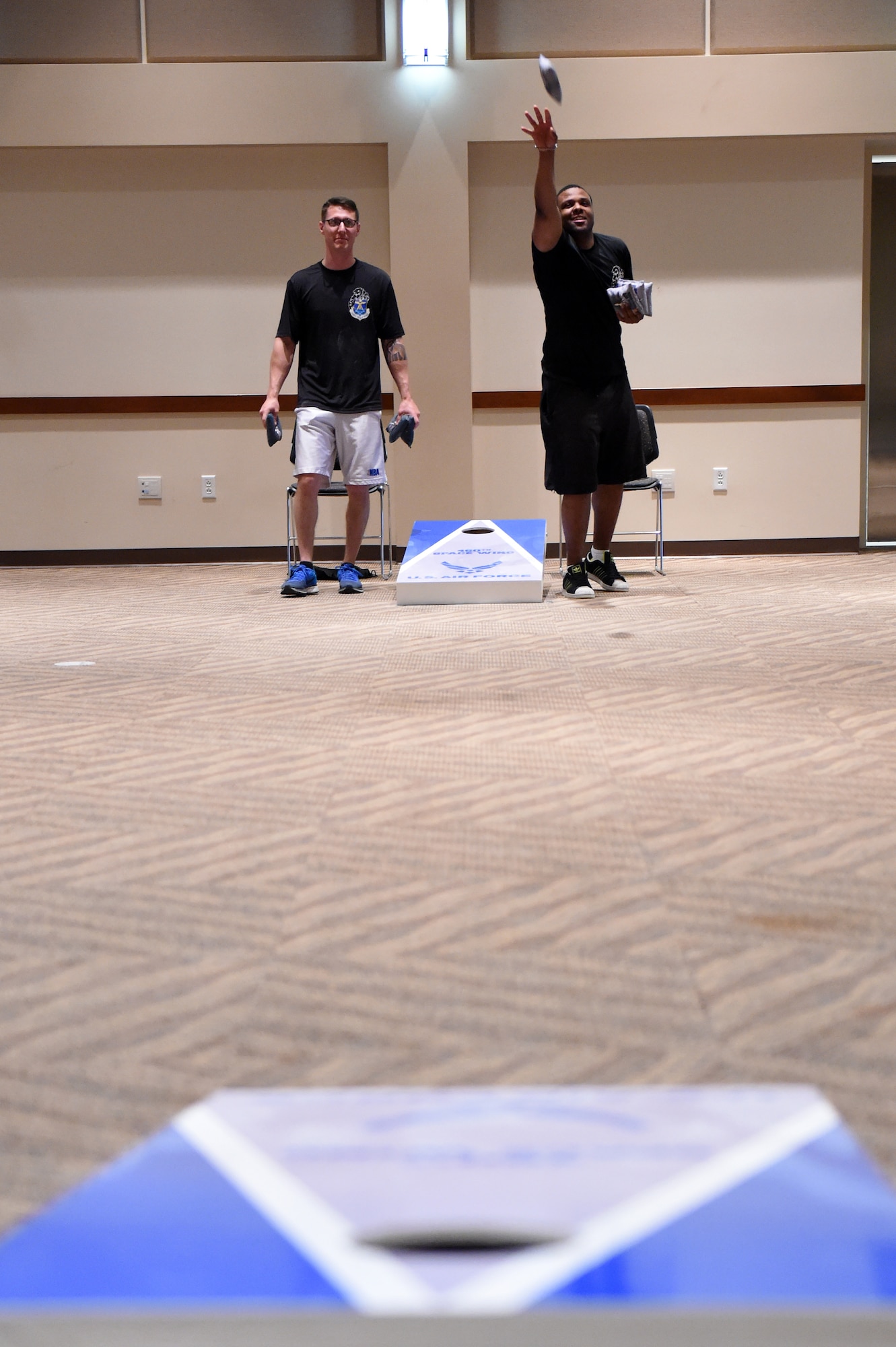 Corn hole players toss bean bags during the Tri-Wing Sports Day competition May 20, 2015, on Buckley Air Force Base, Colo. Tri-Wing Sports Day is held once a year between the three Air Force Space Command bases and is intended to promote healthy, active lifestyles and friendly competition. The bases competed against each other in over 15 sports such as volleyball, football, tennis and softball among others. (U.S. Air Force photo by Airman 1st Class Emily E. Amyotte/Released)