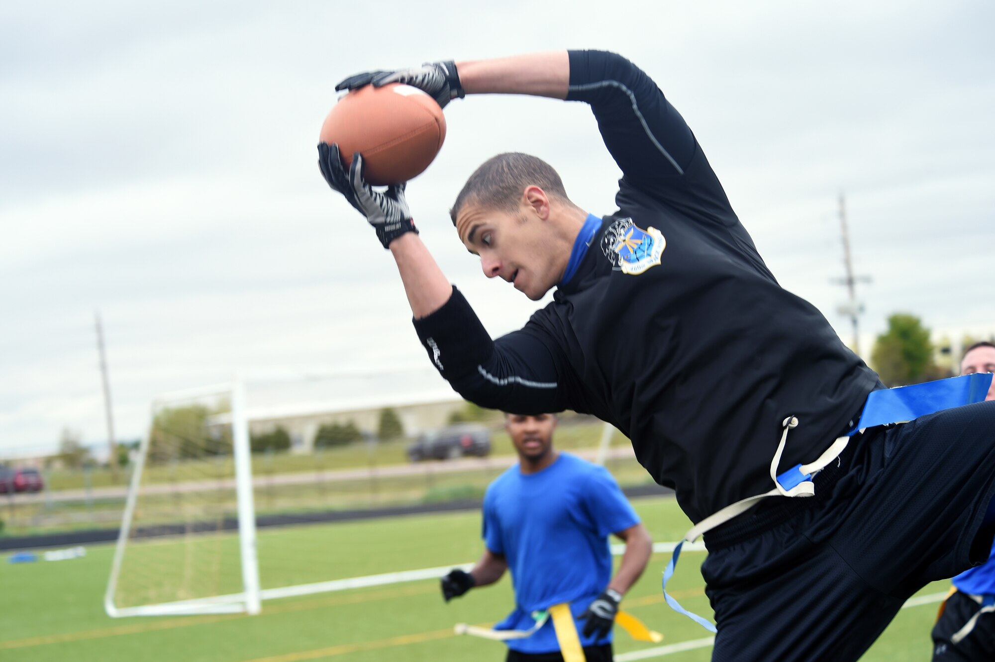 2nd Lt. James MacAndrew, 2nd Space Warning Squadron mission crew commander, grabs the football in mid-air during the Tri-Wing Sports Day competition May 20, 2015, on Buckley AFB, Colo. Tri-Wing Sports Day is held once a year between the three Air Force Space Command bases and is intended to promote healthy, active lifestyles and friendly competition. The bases competed against each other in over 15 sports such as volleyball, football, tennis and softball among others. (U.S. Air Force photo by Airman 1st Class Emily E. Amyotte/Released)