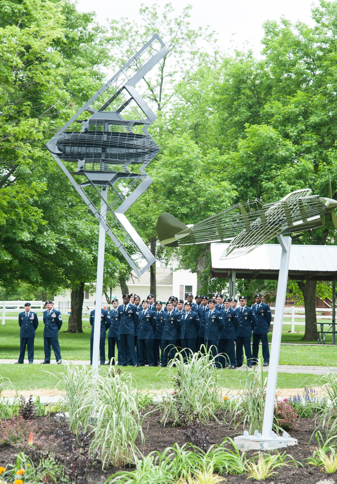 Airmen from the 509th Security Forces Squadron at Whiteman Air Force Base attend a ceremony for the opening of the Whiteman Corridor May 16, 2015, in Sedalia, Mo. The base was named after 2nd Lt. George Whiteman, a Sedalia native who was killed during World War II. The P-40B Warhawk points to lieutenant’s childhood home and represents the past, while the B-2 Spirit stealth bomber points toward the base and represents the future. (U.S. Air Force photo by Staff Sgt. Brigitte N. Brantley/Released)