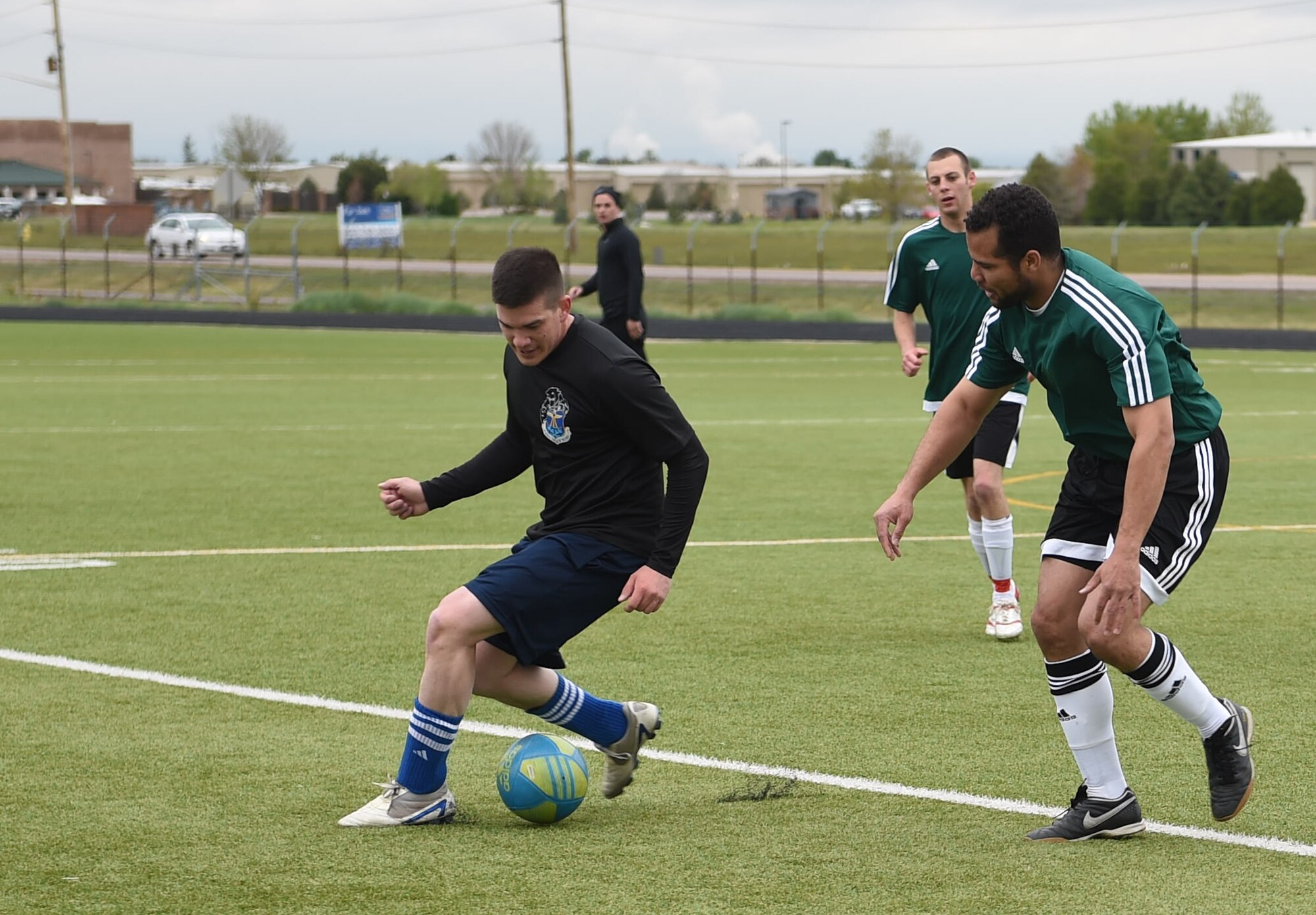 Buckley Air Force Base, Colo. and Peterson AFB, Colo. members compete against each other for 1st place in soccer during the Tri-Wing Sports Day competition May 20, 2015, on Buckley AFB, Colo. Tri-Wing Sports Day is held once a year between the three Air Force Space Command bases and is intended to promote healthy, active lifestyles and friendly competition. The bases competed against each other in over 15 sports such as volleyball, football, tennis and softball among others. (U.S. Air Force photo by Airman 1st Class Samantha Meadors/Released)