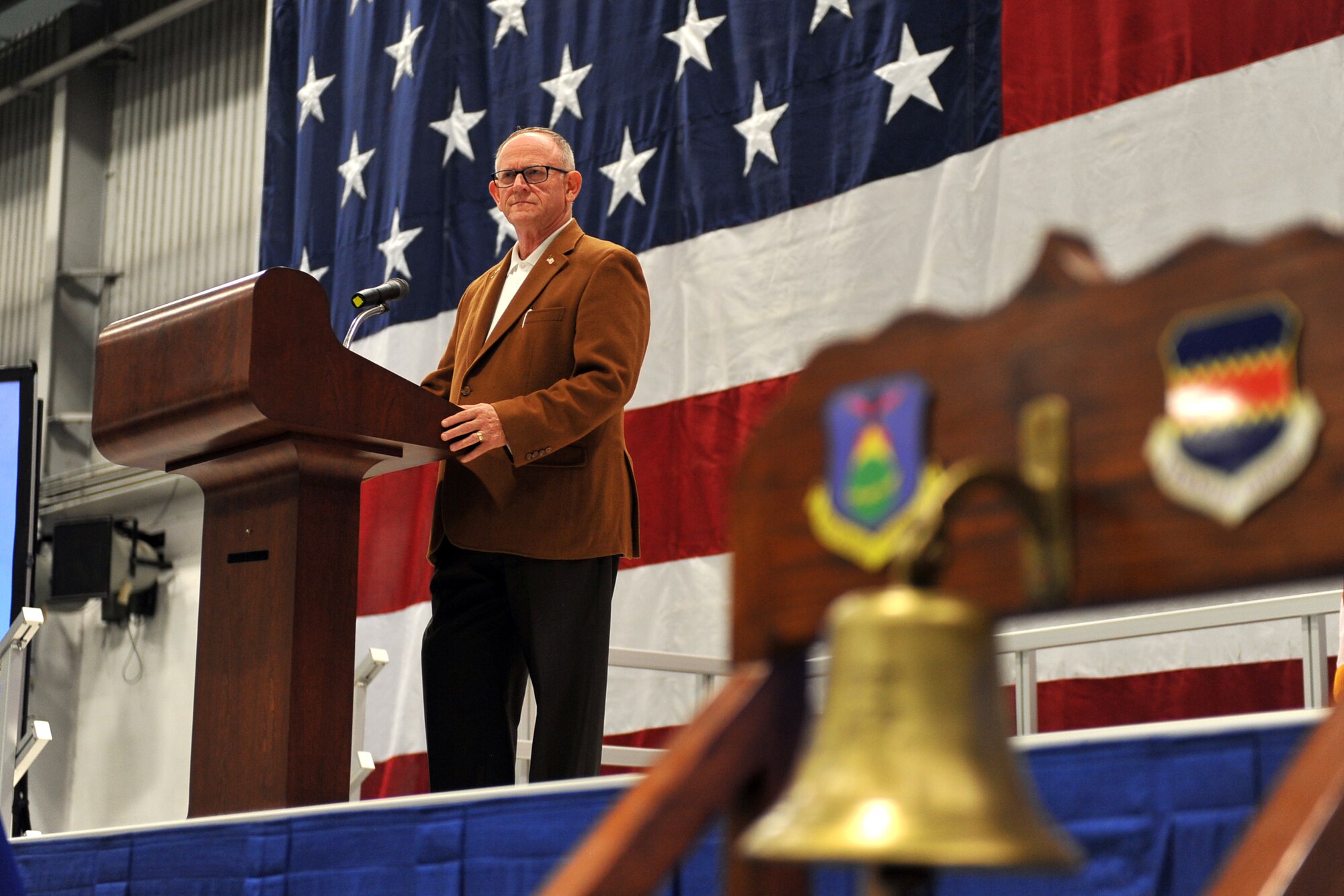 Retired U.S. Air Force Col. Jim Thomas, 55th Wing Association president and emcee for the annual Tales of the 55th ceremony, addresses a hangar full of Airmen inside the Bennie Davis Maintenance Facility on May 15, Offutt Air Force Base, Neb.  The Tales of the 55th is an annual event that brings former and current Fightin’ Fifty-Fifth members together to relive past war stories. (U.S. Air Force photo by Josh Plueger/Released)