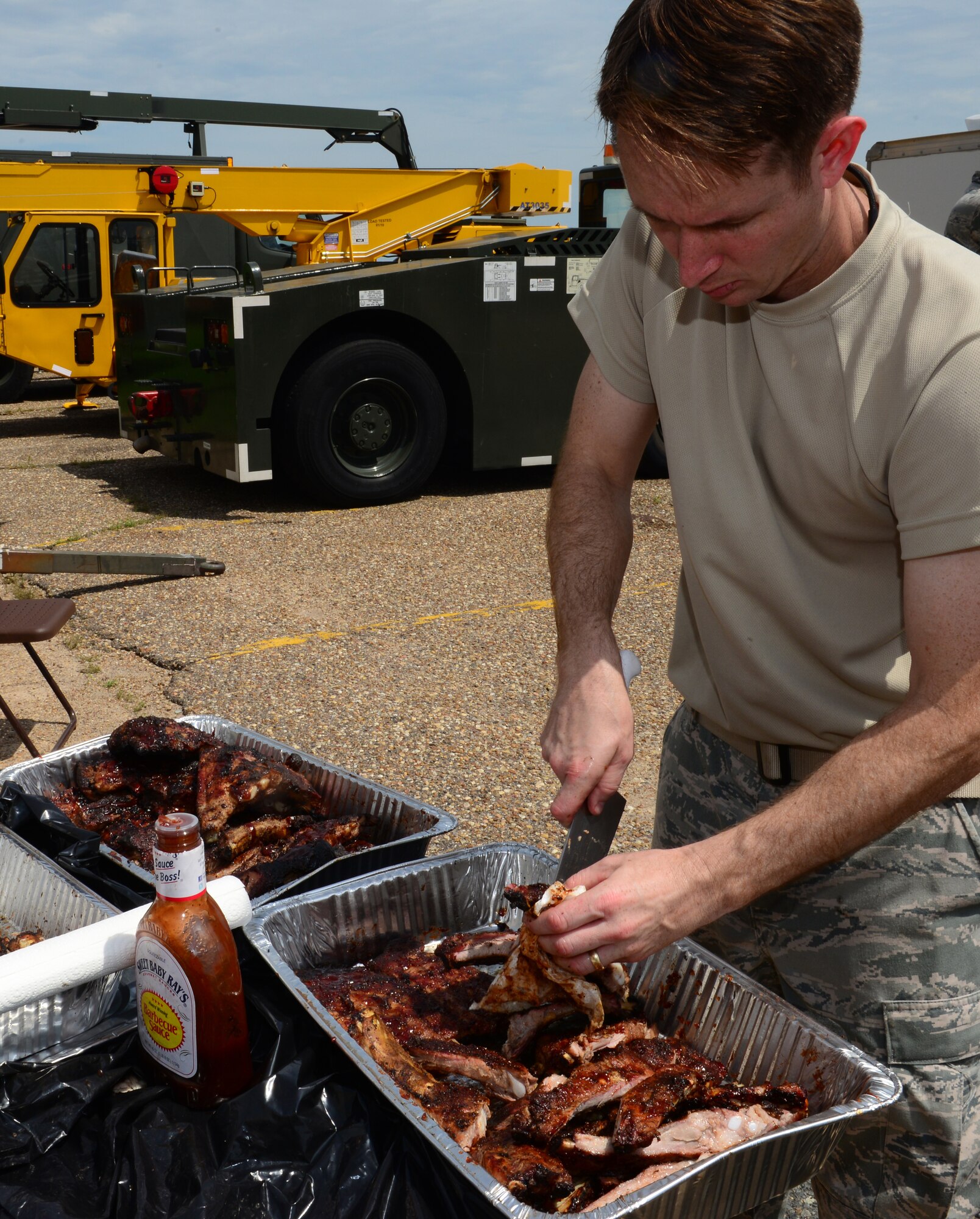 Capt. Jeremy Caudill, 2nd Bomb Wing chaplain, prepares barbeque ribs for the chaplain Corps cookout on Barksdale Air Force Base, Louisiana, May 20, 2015. The Chaplain Corps provides spiritual care and the opportunity for Air Force members and their families to exercise their constitutional right to freedom of religion. (U.S. Air Force Photo/Airman 1st Class Luke Hill)