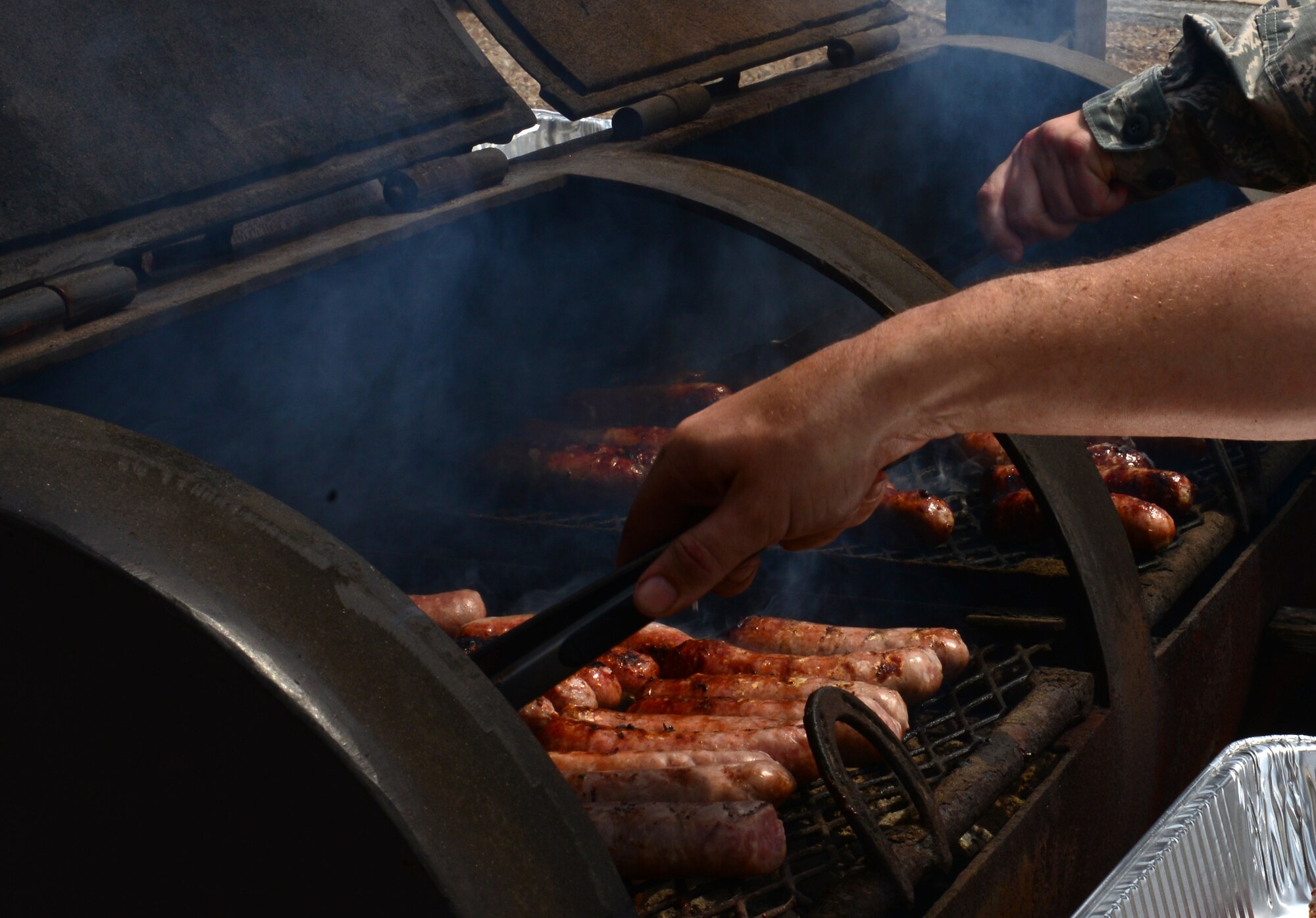 Airmen grill bratwursts and hot dogs for the chaplain corps cookout on Barksdale Air Force Base, Louisiana, May 20, 2015. Volunteers from all over Barksdale spent time grilling and preparing barbeque ribs, bratwursts and hot dogs for the cookout. (U.S. Air Force Photo/Airman 1st Class Luke Hill)