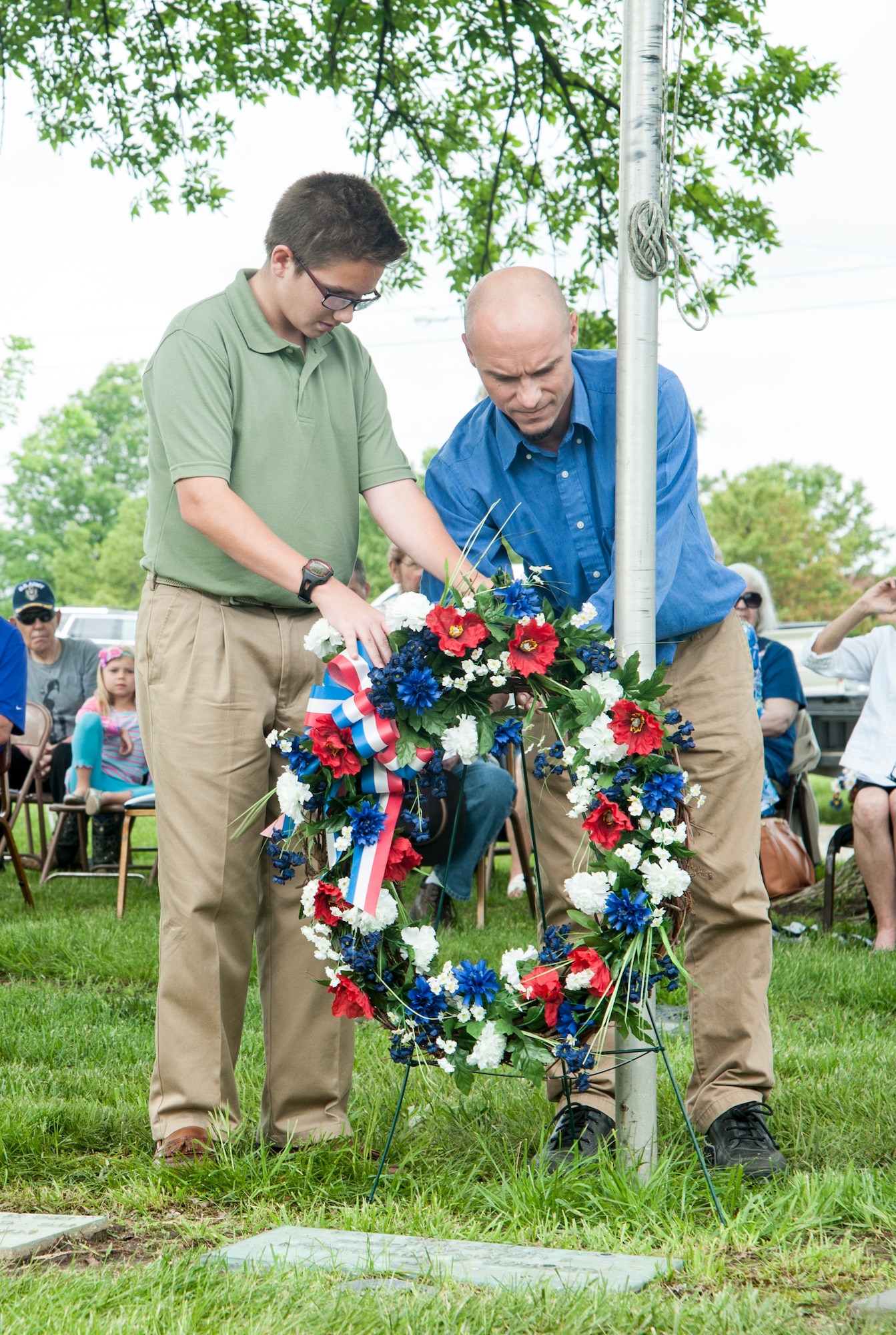 Hunter Fugit, left, and Matt Berry, descendants of 2nd Lt. George Whiteman, lay a wreath at the lieutenant’s grave during the annual ceremony May 16, 2015, in Sedalia, Mo. Whiteman, believed to be the first Airman killed during World War II, was the oldest of nine brothers and sisters. (U.S. Air Force photo by Staff Sgt. Brigitte N. Brantley/Released)