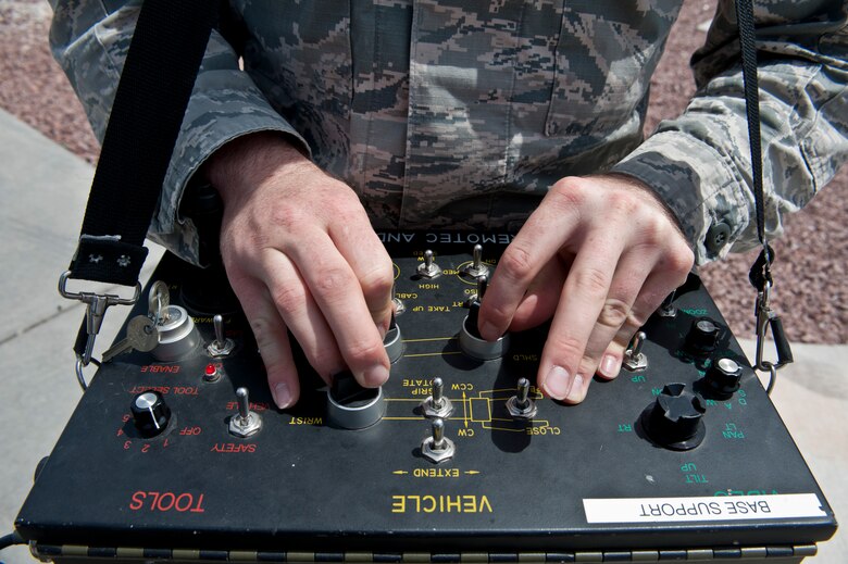 Senior Airman Wyland Wacaser, 99th Civil Engineer Squadron explosive ordnance disposal journeyman, operates the F6A robot by using the control panel on Nellis Air Force Base, Nev., May 13, 2015. The F6A robot helps EOD Airmen move in on a suspicious package while also being away at a safe distance. (U.S. Air Force photo by Airman 1st Class Jake Carter)