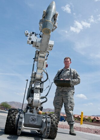 Senior Airman Wyland Wacaser, 99th Civil Engineer Squadron explosive ordnance disposal journeyman, operates the F6A robot by lifting up an inert unexploded ordnance on Nellis Air Force Base, Nev., May 13, 2015. Equipment that EOD uses consists of the F6A robot, bomb suit, various explosive tools as well as various aircraft tools as well to help support their mission. (U.S. Air Force photo by Airman 1st Class Jake Carter)