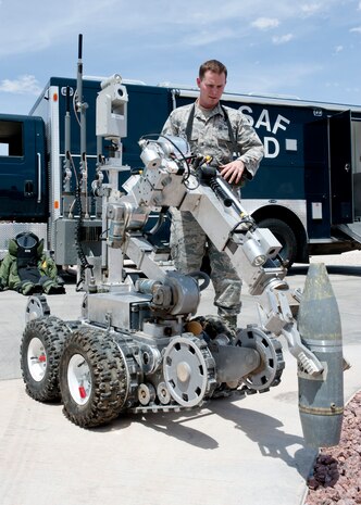 Senior Airman Wyland Wacaser, 99th Civil Engineer Squadron explosive ordnance disposal journeyman, operates the F6A robot by picking up an inert unexploded ordnance on Nellis Air Force Base, Nev., May 13, 2015. Airmen at EOD can work alongside the Las Vegas Metropolitan Police and  Fire Departments if there is any military ordnance or if advice is wanted. (U.S. Air Force photo by Airman 1st Class Jake Carter)