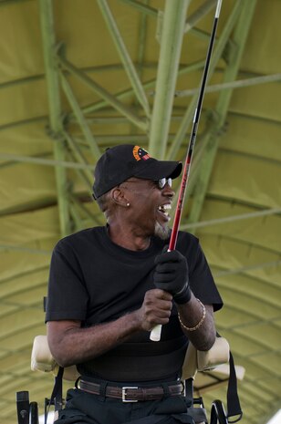 Walter McGee, retired U.S. Marine Corps member, celebrates after hitting the ball at the driving range on Nellis Air Force Base, Nev., May 14, 2015. With the assistance of the Professional Golfers’ Association of America Hope Program, this was the first time McGee has played golf since 2001. (U.S. Air Force photo by Airman 1st Class Mikaley Towle) 