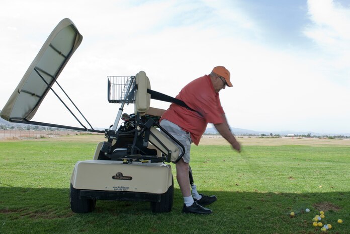 Duane Poser, retired U.S. Army battery clerk, takes a swing at a golf ball at the driving range on Nellis Air Force Base, Nev., May 14, 2015. With the assistance of the Professional Golfers’ Association of America Hope Program, this was the first time Poser has played golf in approximately three years. (U.S. Air Force photo by Airman 1st Class Mikaley Towle)