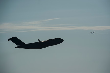Two C-17 Globemaster IIIs are in flight May 21, 2015, at Joint Base Charleston, S.C. during exercise Crescent Reach 2015. The exercise tested JB Charleston’s ability to launch a large aircraft formation and mobilize a large amount of cargo and passengers. (U.S. Air Force photo/Senior Airman Jared Trimarchi)