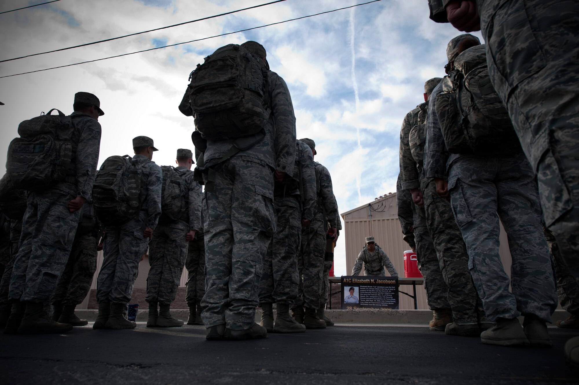 Lt. Col. Joseph Ringer, 99th Security Forces Squadron commander, leads his formation in recognition of Airman First Class Elizabeth Jacobson during the National Police Week 10K memorial ruck march at Nellis Air Force Base, Nev., May 13, 2015. Jacobson, a security forces Airman who was killed performing convoy security in support of Operation Iraqi Freedom, was honored along with other fallen members of the law enforcement community at the numerous stops made by the formation along their route. (U.S. Air Force photo by Senior Airman Joshua Kleinholz)