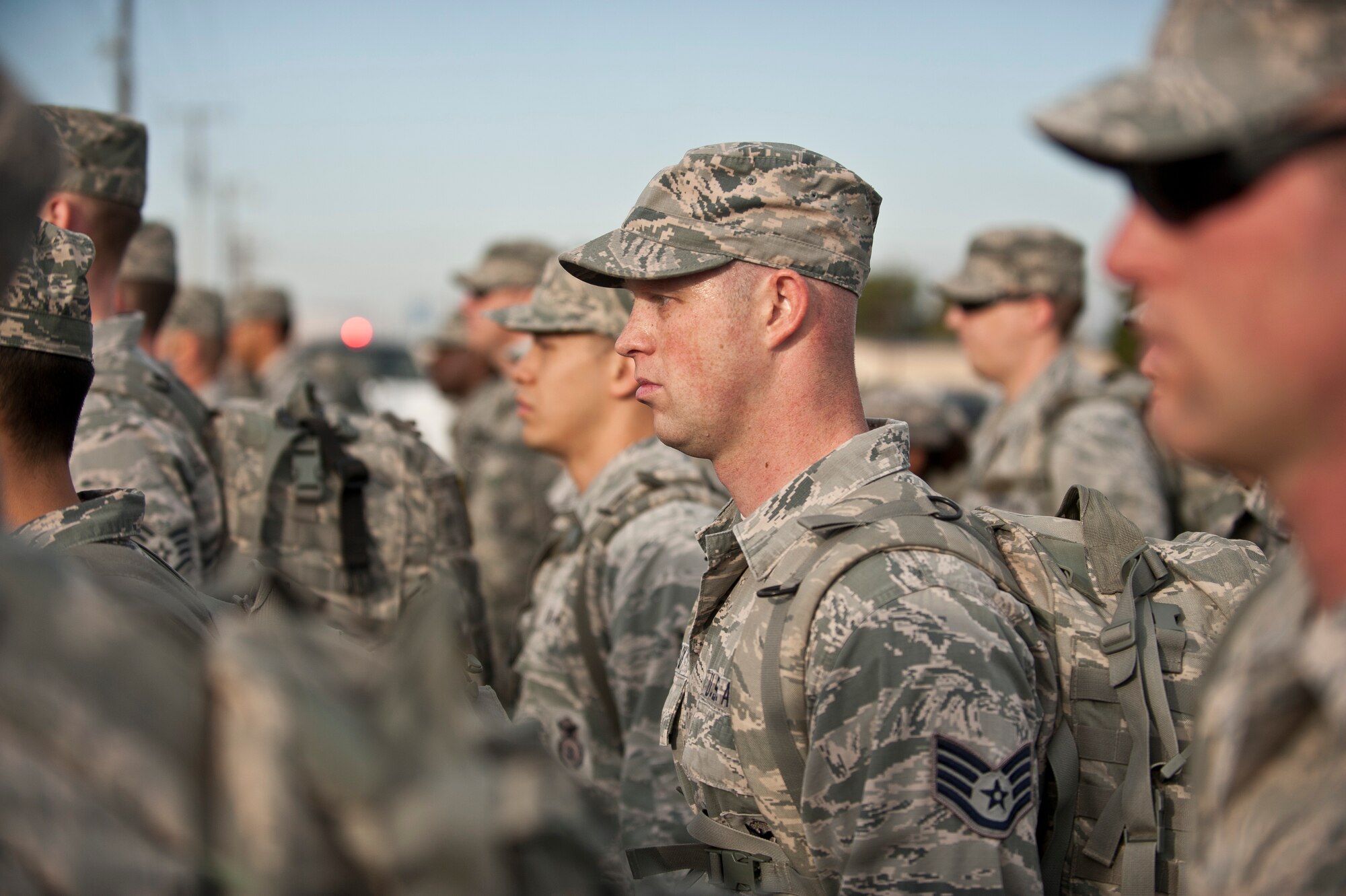 Airmen assigned to the 99th Security Forces Squadron stand in formation during a 10K memorial ruck march for National Police Week at Nellis Air Force Base, Nev., May 13, 2015. The event was held to commemorate National Police Week, and honor fallen Air Force security forces members. (U.S. Air Force photo by Staff Sgt. Siuta B. Ika)