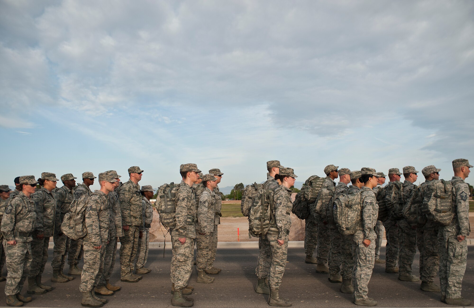 Airmen assigned to the 99th Security Forces Squadron stand in formation during a 10K memorial ruck march for National Police Week at Nellis Air Force Base, Nev., May 13, 2015. Throughout the march, the formation stopped to honor wingmen who were killed in the line of duty. (U.S. Air Force photo by Staff Sgt. Siuta B. Ika)