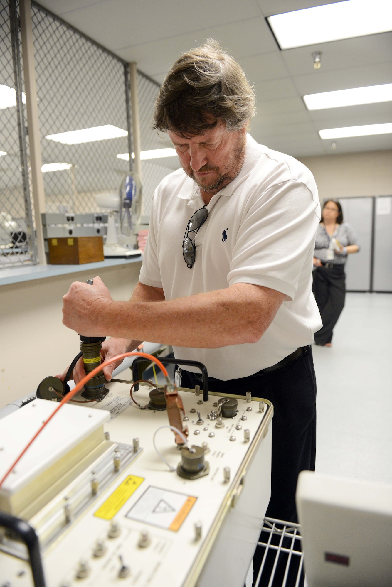 James Annis, Automatic Test Systems Division program manager, connects cables to the CMBRE adapter. (U.S. Air Force photo by Tommie Horton)