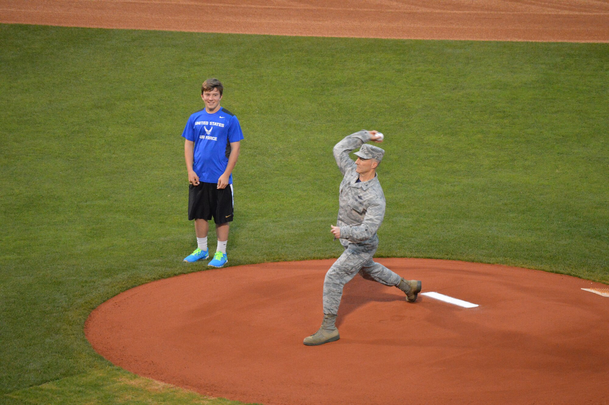 With his son Steven looking on, Col Christopher Azzano throws out the ceremonial first pitch of the game.  Colonel Azzano is the 72nd Air Base Wing and Tinker installation commander.  (Air Force photo by April McDonald/Released)