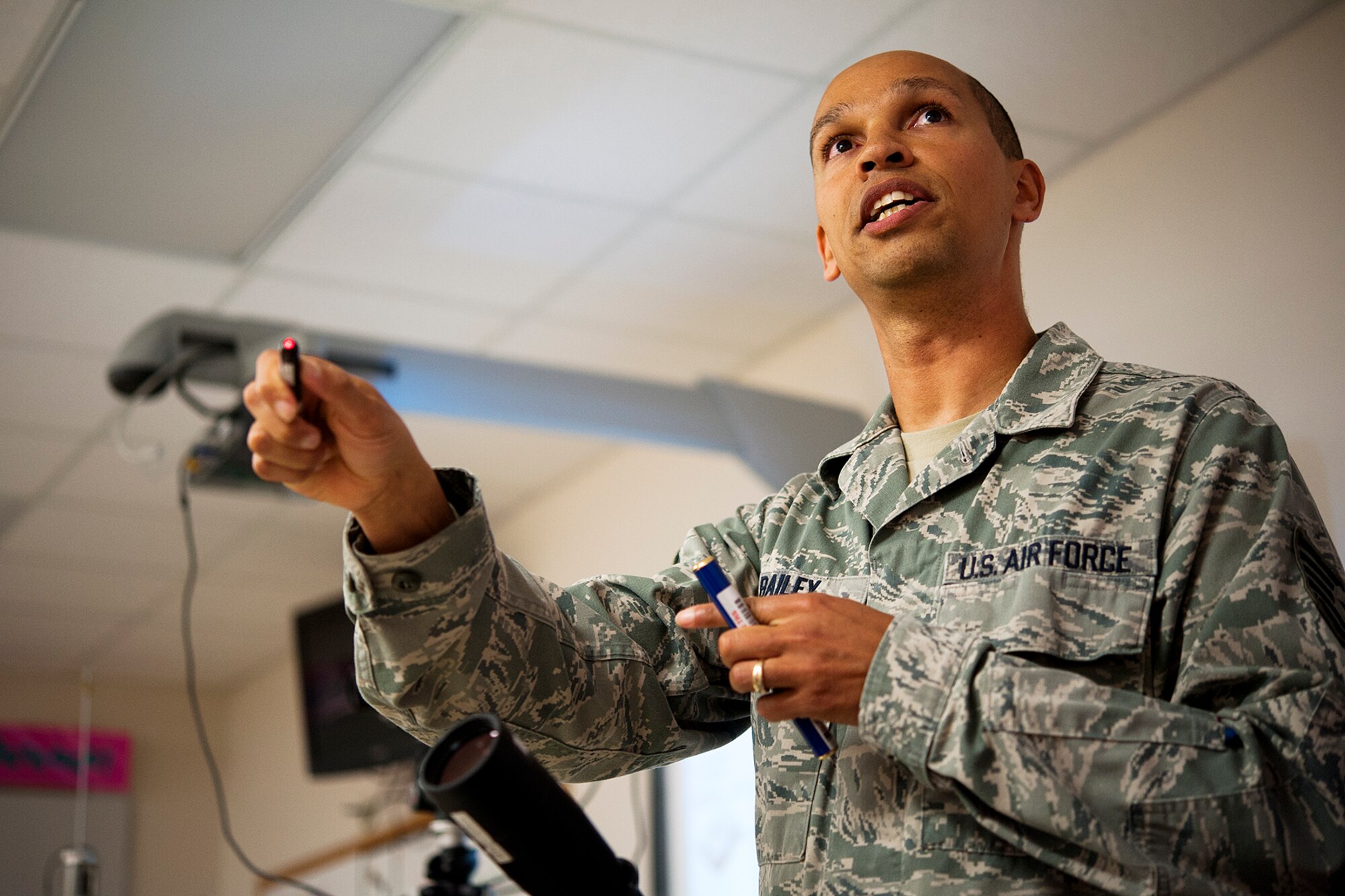 U.S. Air Force Tech. Sgt. Christopher L. Bailey, 312th Training Squadron instructor supervisor, points a red laser at a classroom wall at Lee Middle School in San Angelo, Texas, May 19, 2015. Bailey taught 8th grade students about the visible light spectrum and how his tools can measure the true color of light from any light source. (U.S. Air Force photo by Airman 1st Class Devin Boyer/Released)