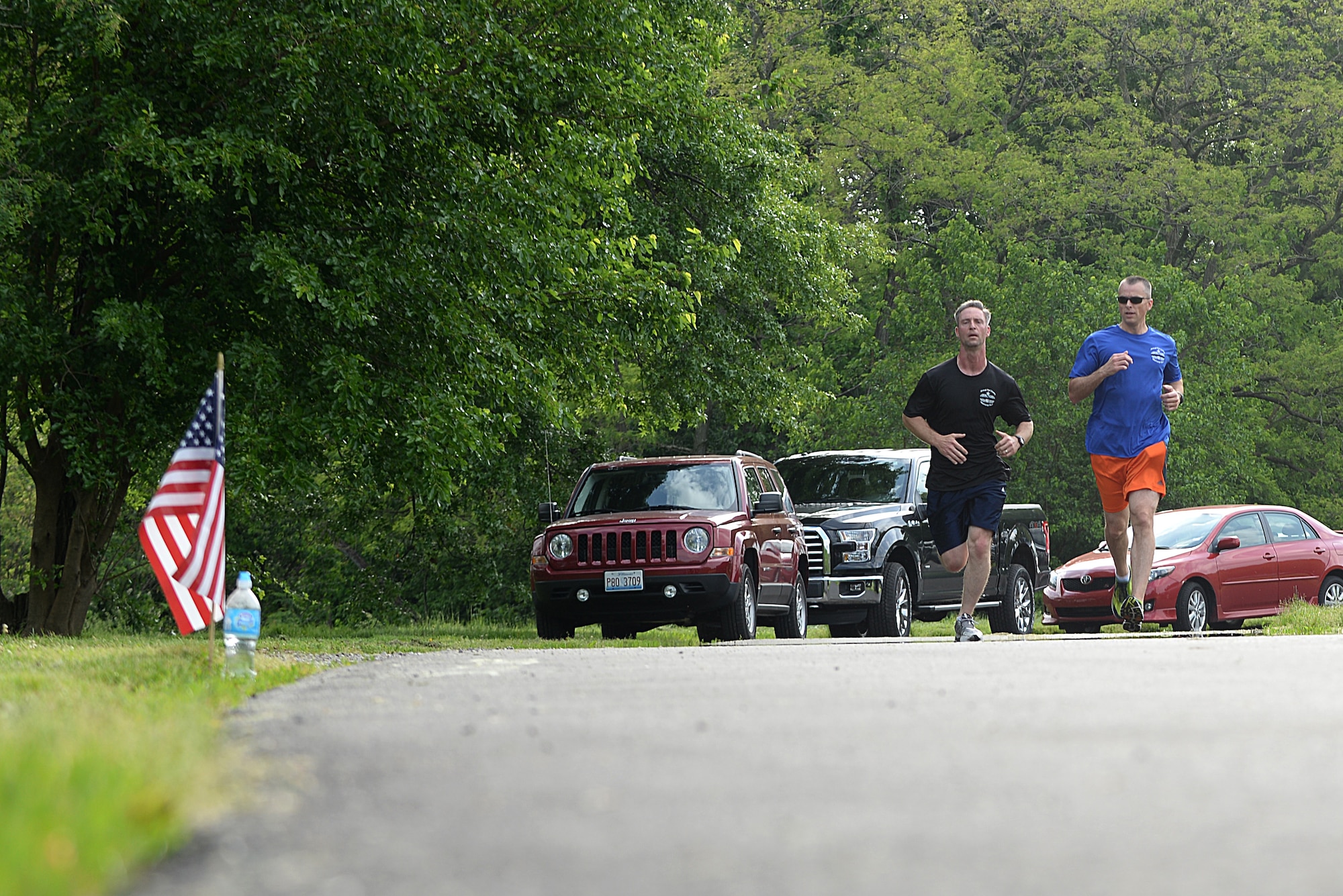 Team Scott members pass by flags with names of fallen Port Dawgs during the Port Dawgs Memorial Run 5k around Scott Lake May 15, 2015 at Scott Air Force Base, Illinois. Names were written along the path in honor of fallen Aerial Transporters or “Port Dawgs.” (U.S. Air Force photo/Senior Airman Joshua Eikren)
