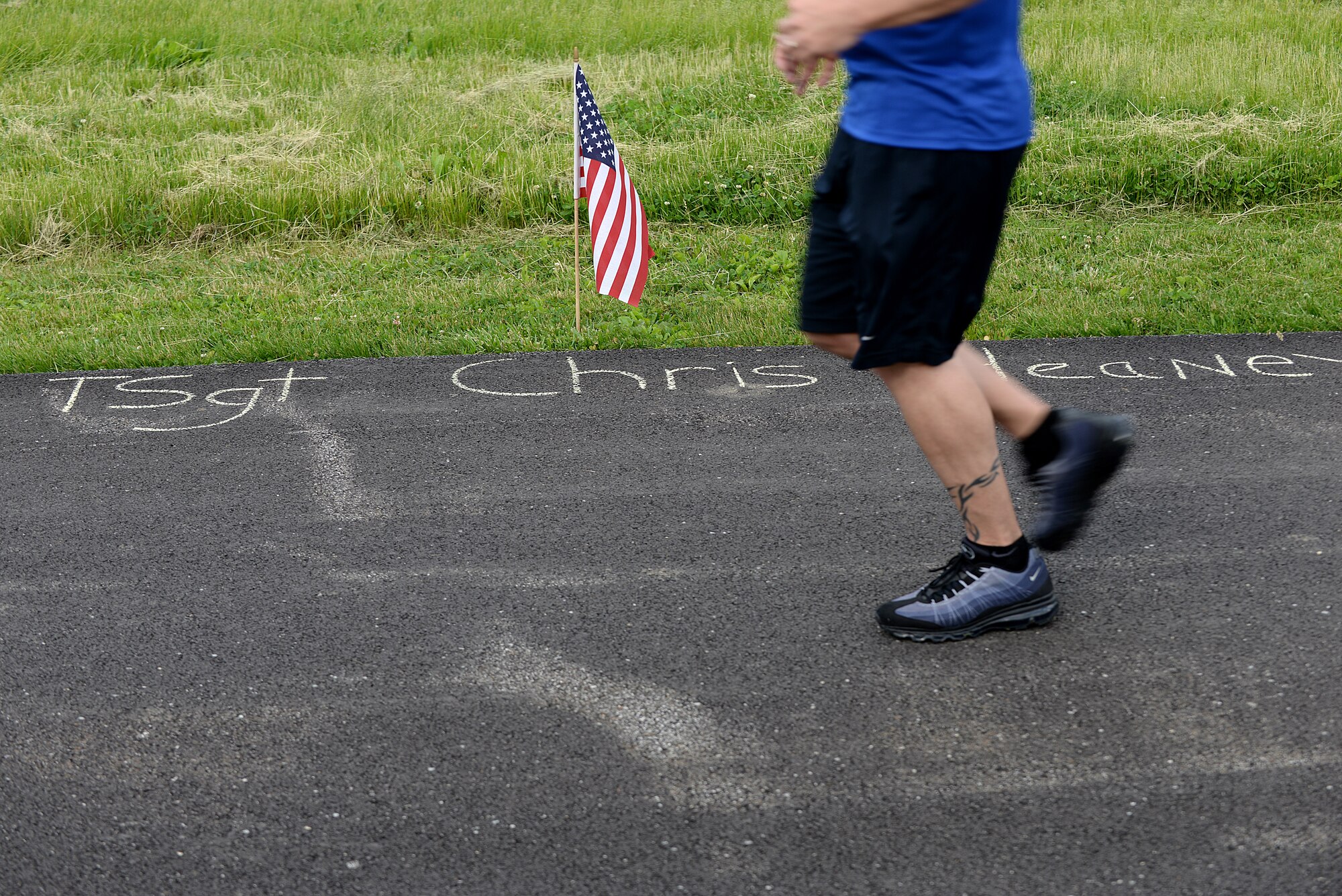 Team Scott members pass by flags with names of fallen Port Dawgs during the Port Dawgs Memorial Run 5k around Scott Lake May 15, 2015 at Scott Air Force Base, Illinois. Names were written along the path in honor of fallen Aerial Transporters or “Port Dawgs.” (U.S. Air Force photo/Senior Airman Joshua Eikren)