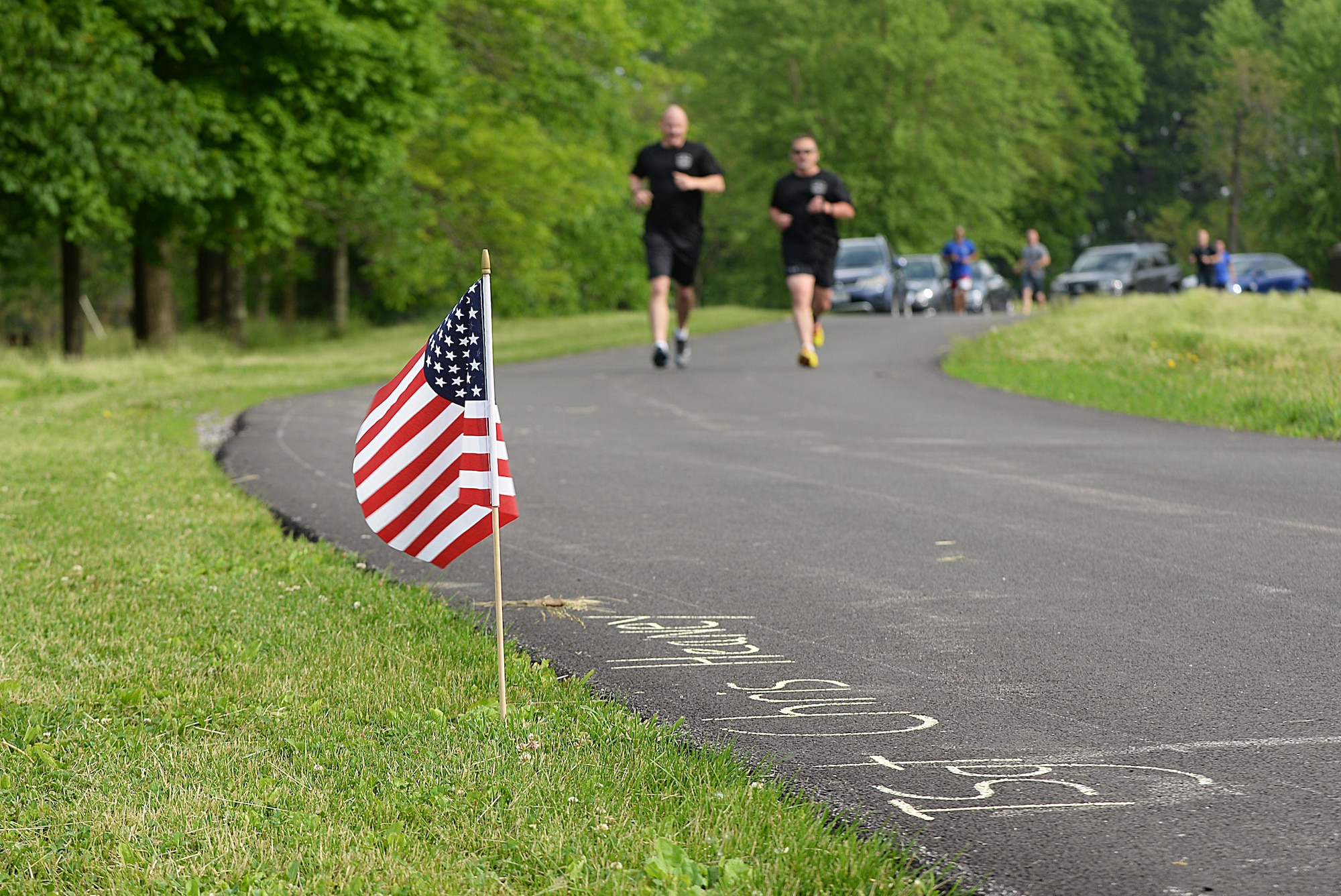 Team Scott members pass by flags with names of fallen Port Dawgs during the Port Dawgs Memorial Run 5k around Scott Lake May 15, 2015 at Scott Air Force Base, Illinois. Names were written along the path in honor of fallen Aerial Transporters or “Port Dawgs.” (U.S. Air Force photo/Senior Airman Joshua Eikren)