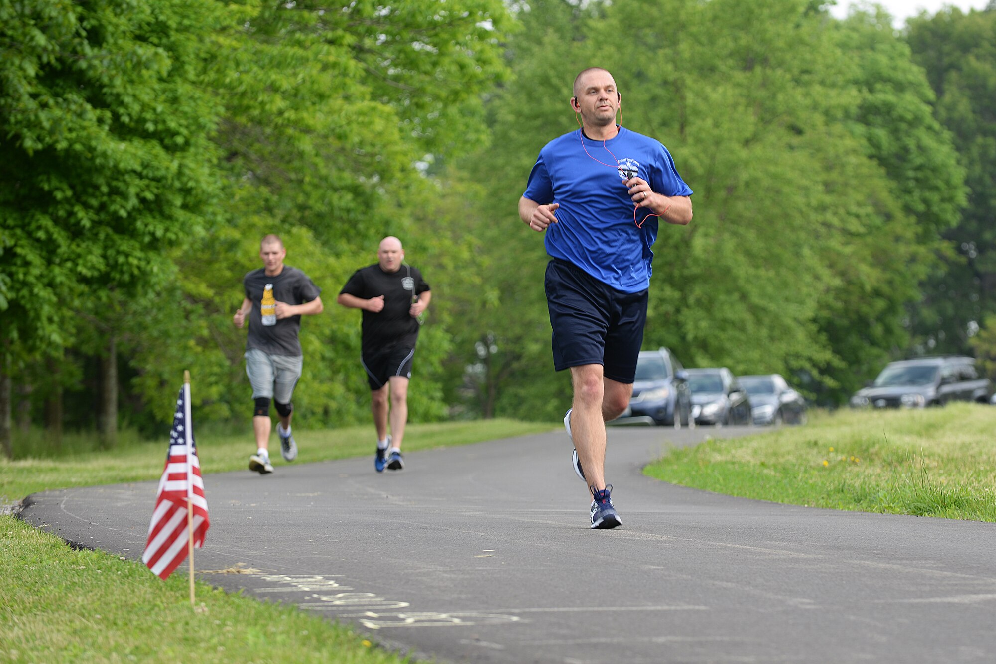 Team Scott members pass by flags with names of fallen Port Dawgs during the Port Dawgs Memorial Run 5k around Scott Lake May 15, 2015 at Scott Air Force Base, Illinois. Names were written along the path in honor of fallen Aerial Transporters or “Port Dawgs.” (U.S. Air Force photo/Senior Airman Joshua Eikren)