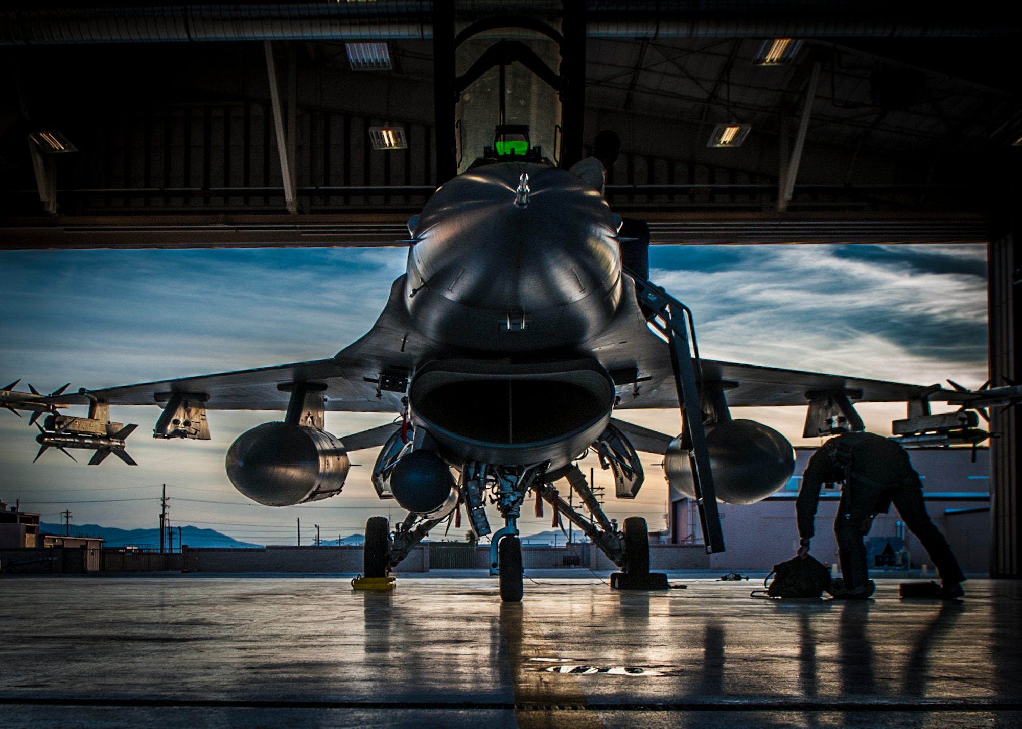 An F-16 Fighting Falcon sits in a hangar prior to departure at Holloman Air Force Base, N.M. May 13, 2015. F-16 students from the 311th Fighter Squadron, a tenant until from Luke Air Force Base, Ariz., are currently flying night operations as part of their syllabus. During the night operations, the students are becoming familiarized with night vision goggles while performing combat training missions. (U.S. Air Force photo by Airman 1st Class Emily A. Kenney/Released)