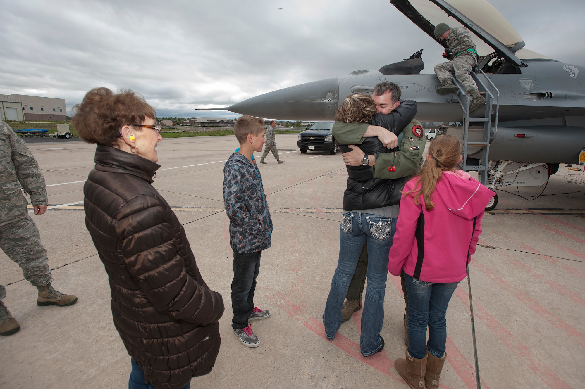 U.S. Air Force Maj. Brett Berringer's family welcomes him home after landing an F-16 Fighting Falcon from the 120th Fighter Squadron, Colorado Air National Guard, at Buckley Air Force Base, Colo., upon his return from a deployment to the Republic of Korea, May 19, 2015. Integrating with other U.S. Air Force members, flying daily training mission and providing a Theater Security Package for the past 90 days, this return home marks the completion of the seventh deployment for the "Redeyes" of the 120th FS along with the 140th Wing since Sept. 11, 2001. (U.S. Air National Guard photo by: Tech. Sgt. Wolfram M. Stumpf/RELEASED)