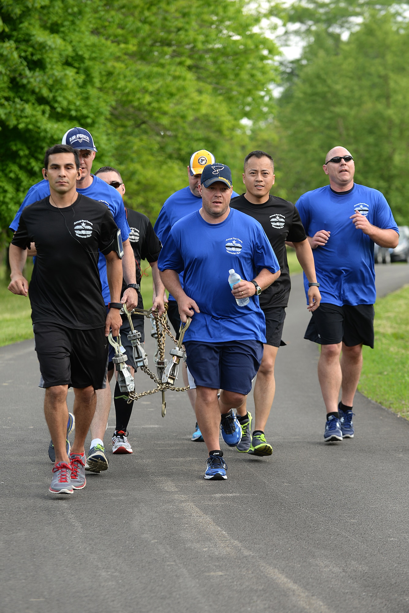 Team Scott members carry a chain during the Port Dawgs Memorial Run 5k around Scott Lake May 15, 2015 at Scott Air Force Base, Illinois. The run was held in honor of fallen Aerial Transporters or “Port Dawgs” and each device on the chain represented a fallen member they were remembering. (U.S. Air Force photo/Senior Airman Joshua Eikren)