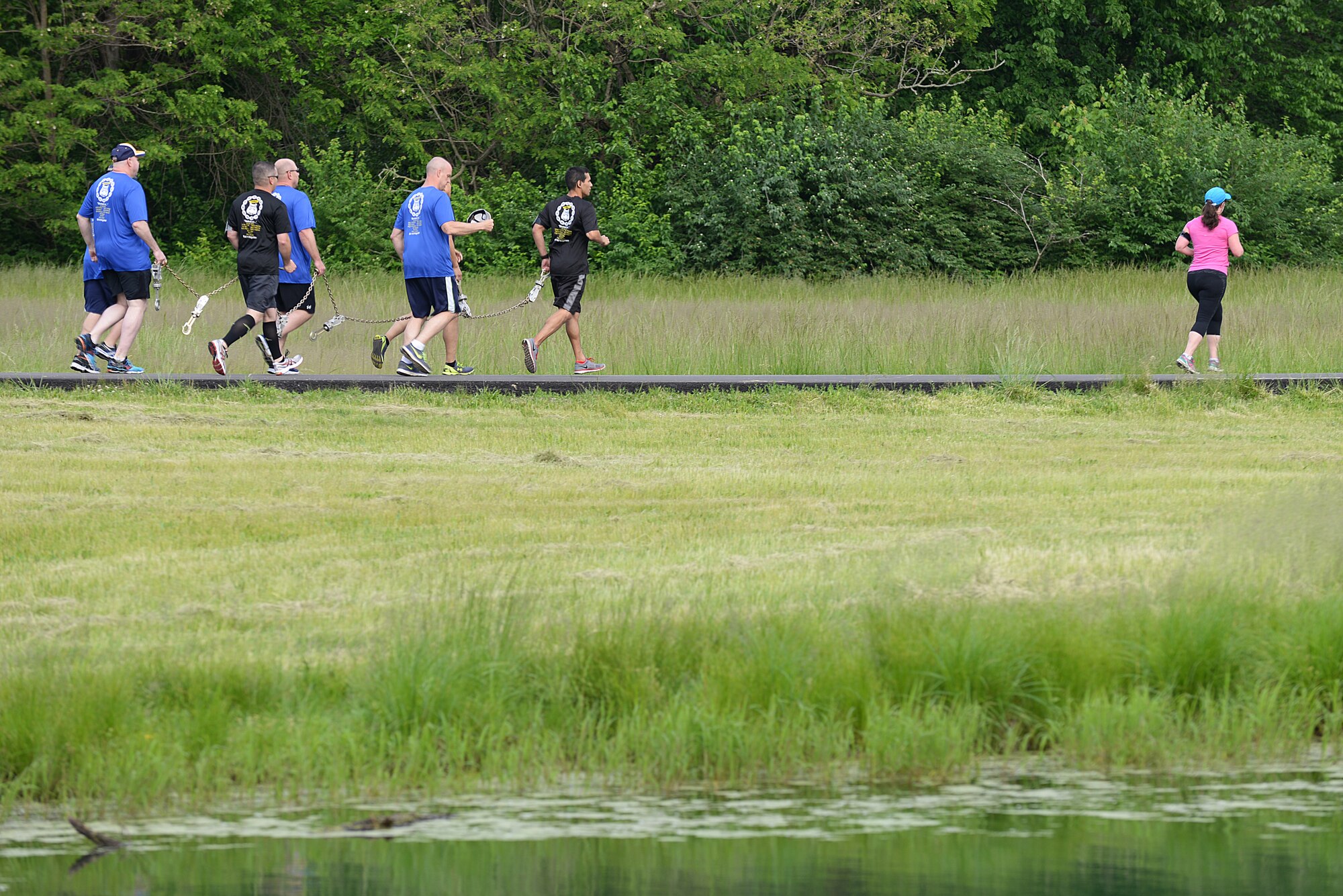 Team Scott members carry a chain during the Port Dawgs Memorial Run 5k around Scott Lake May 15, 2015 at Scott Air Force Base, Illinois. The run was held in honor of fallen Aerial Transporters or “Port Dawgs” and each device on the chain represented a fallen member they were remembering. (U.S. Air Force photo/Senior Airman Joshua Eikren)