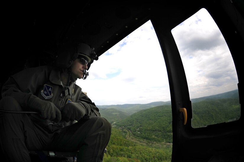 Staff Sgt. Matthew Hawkins, 1st Helicopter Squadron flight engineer, scans the horizon from a UH-1N Twin Huey at Camp Dawson, W.Va., May 15, 2015. Flight engineers are system experts and assist the pilot in various operations, including: calculating weight and balance, takeoff/landing data and navigation. (U.S. Air Force photo/ Airman 1st Class J.D. Maidens)
