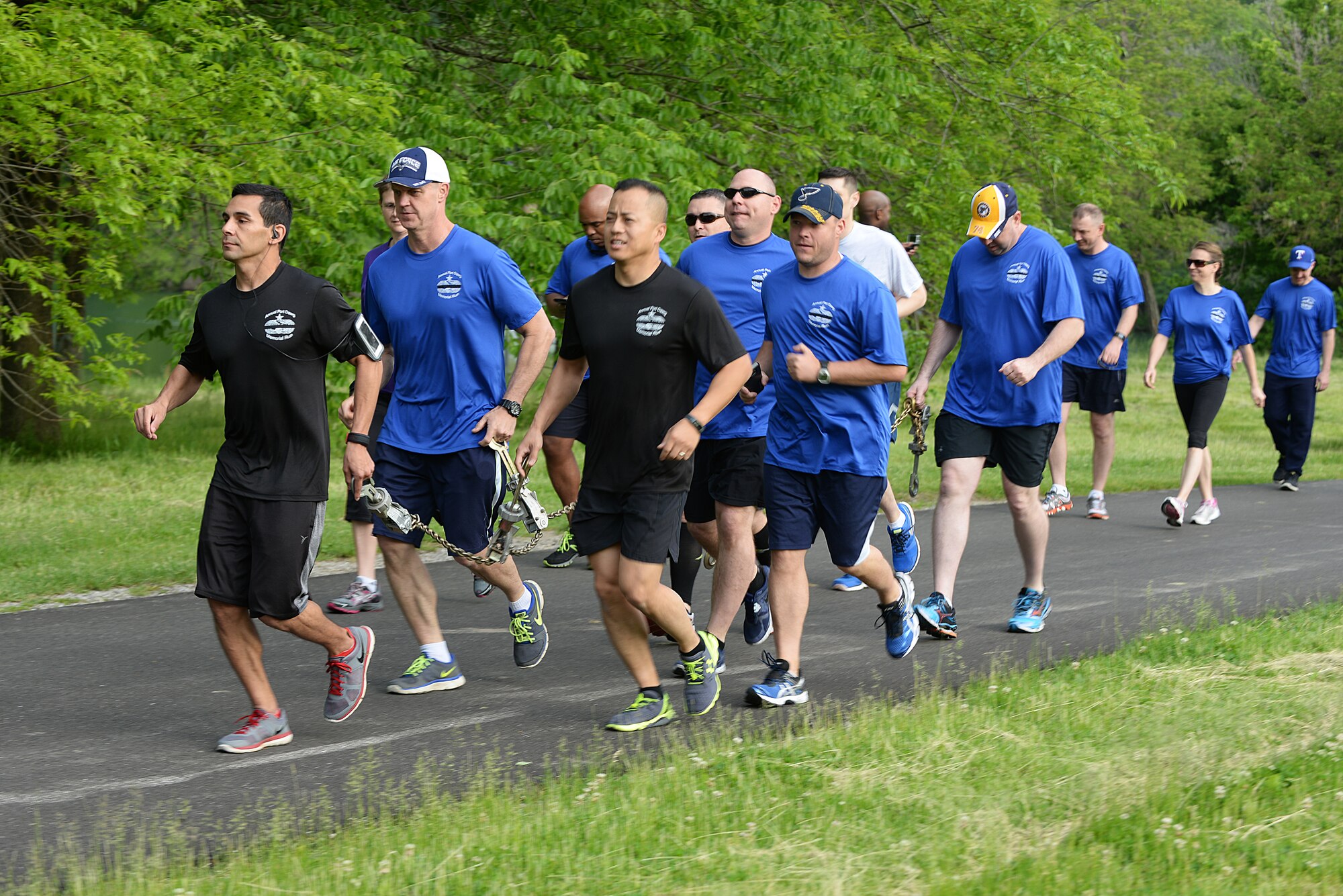 Team Scott members carry a chain during the Port Dawgs Memorial Run 5k around Scott Lake May 15, 2015 at Scott Air Force Base, Illinois. The run was held in honor of fallen Aerial Transporters or “Port Dawgs” and each device on the chain represented a fallen member they were remembering. (U.S. Air Force photo/Senior Airman Joshua Eikren)