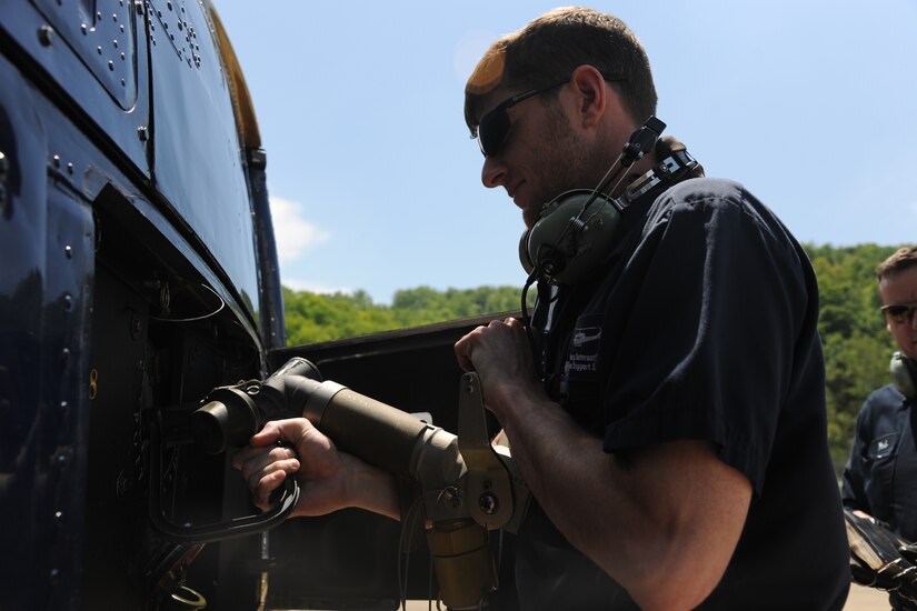 Jason Gast, Dynacorp crew chief, fuels a UH-1N Twin Huey at Camp Dawson, W.Va., May 15, 2015. The 811th Operations Group practiced safely maintained 1st Helicopter Squadron helicopters during a natural disaster exercise. (U.S. Air Force photo/ Airman 1st Class J.D. Maidens)