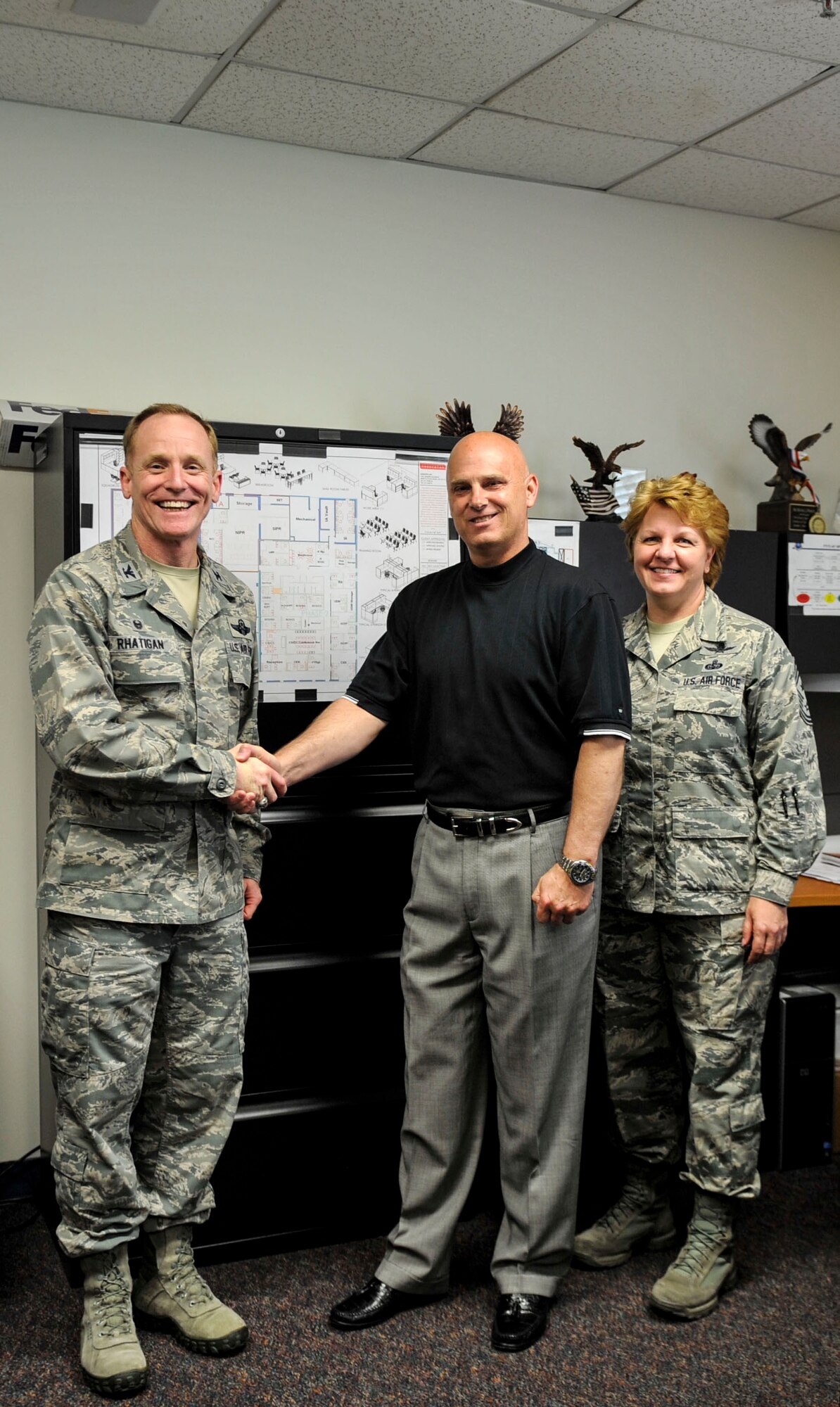 Col. Patrick Rhatigan, 19th Airlift Wing commander, along with Chief Master Sgt. Rhonda Buening, 19th Airlift Wing command chief, congratulate Mike Webster, a 19th Communications Squadron plans and programs project manager, for his selection as Combat Airlifter of the Week May 18, 2015, at Little Rock Air Force Base, Ark. Webster oversaw information technology requirements for 11 major projects on Little Rock Air Force Base, totaling $8.3 million. (U.S. Air Force photo by Senior Airman Stephanie Serrano)