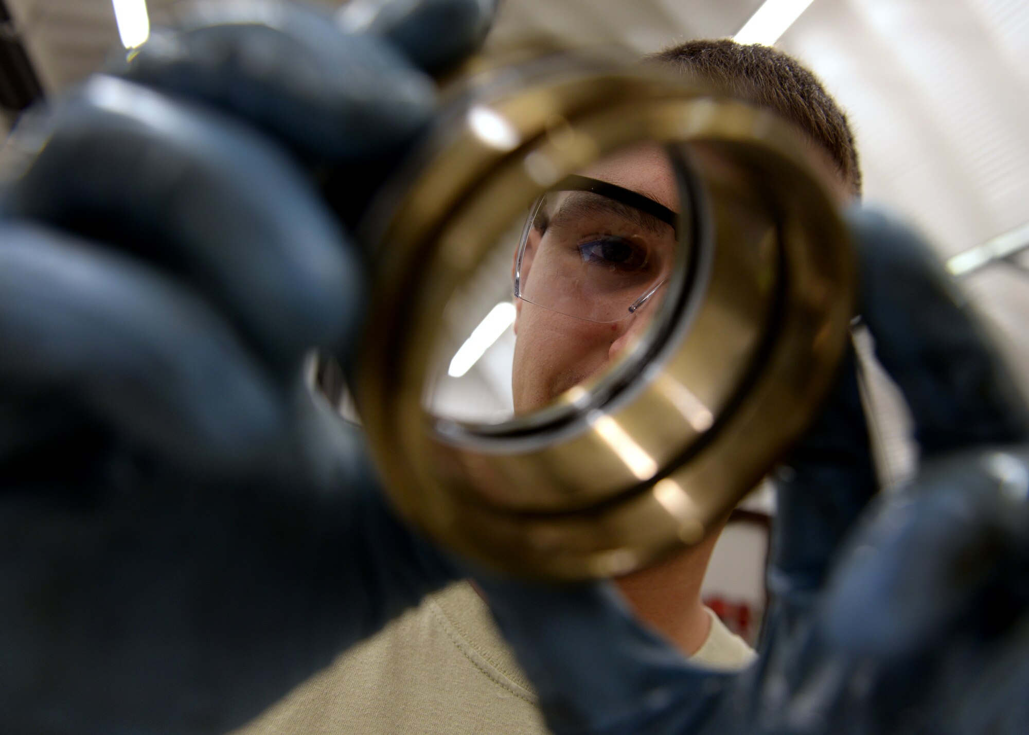 U.S. Air Force Airman 1st Class Steven Jakubowski, 31st Maintenance Squadron hydraulic section apprentice, inspects damage on a retaining ring, May 18, 2015, at Aviano Air Base, Italy.  Each part must be removed in sequence, washed and inspected to ensure the landing gear’s integrity.  (U.S. Air Force photo by Airman 1st Class Cary Smith/Released)