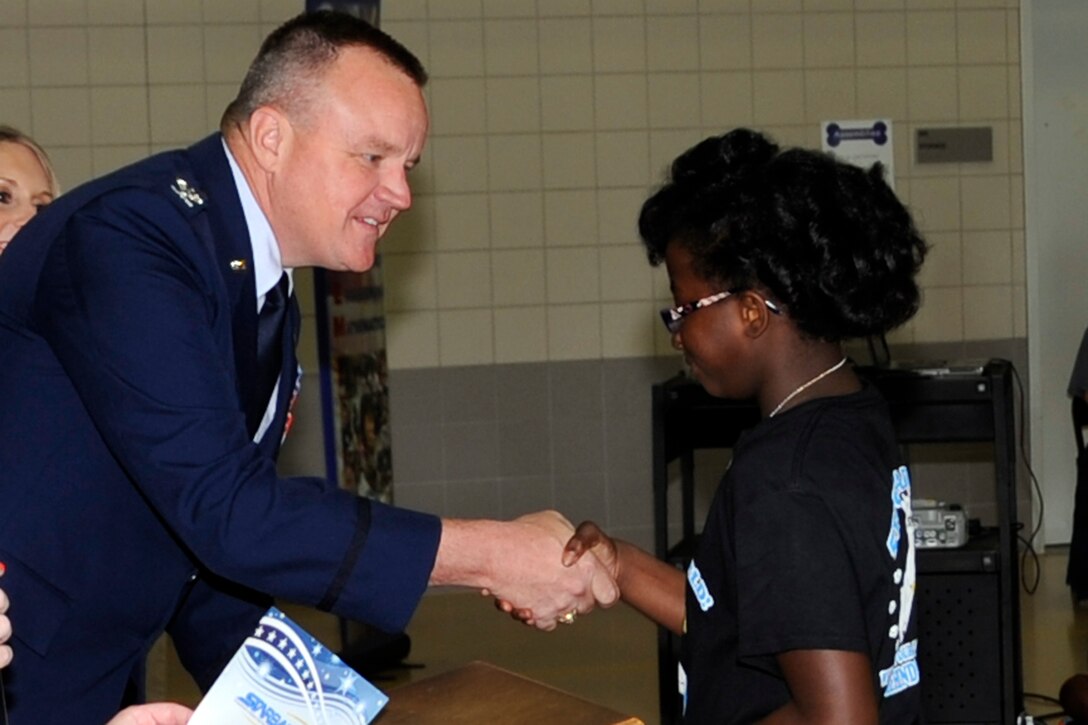 A graduate of the 900th STARBASE Class at W.T. Lewis Elementary School in Bossier City, La. receives congratulation from U.S. Air Force Reserve Col. Bruce Cox, Commander of the 307th Bomb Wing. The STARBASE encourages students to actively engage in STEM (science, technology, engineering, and mathematics) exploration and pursue these areas in future studies. Some of the topics experienced at STARBASE are STEM, Rocketry, Phases of matter and many, many more. (U.S. Air Force photo by Master Sgt. Laura Siebert/Released)