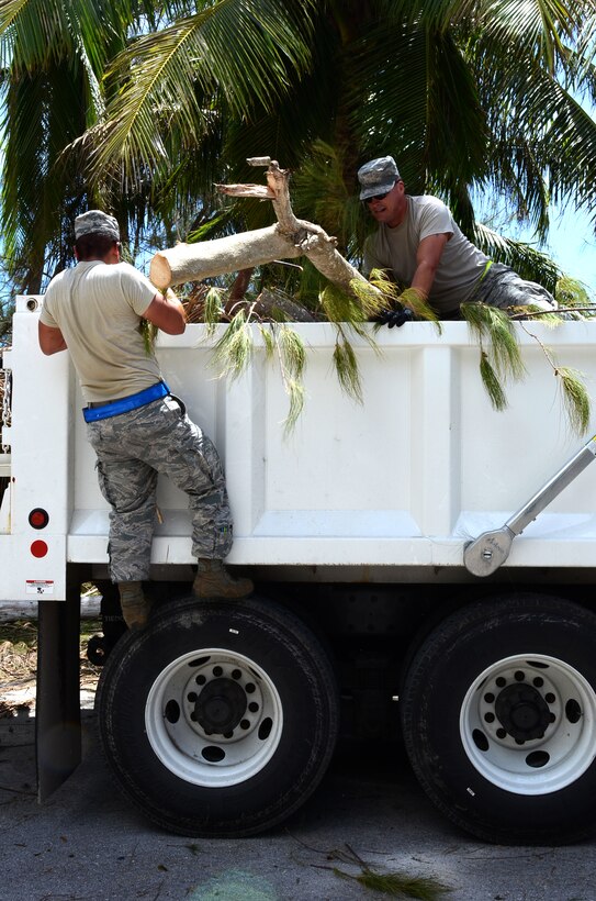 Staff Sgt. Remington Finney (left), 2nd Aircraft Maintenance Squadron from Barksdale Air Force Base, La., and Tech. Sgt. Kevin Wulf, 644th Combat Communications Squadron, lift a large piece of lumber into the back of a dump truck at Tarague Beach on Andersen AFB, Guam, May 21, 2015.  Andersen personnel including 36th Wing Airmen, Guam National Guard and Reserves, and Andersen Army and Navy tenant units participated in clean-up efforts to recover from Typhoon Dolphin. (U.S. Air Force photo by Alexa Ann Henderson/Released)