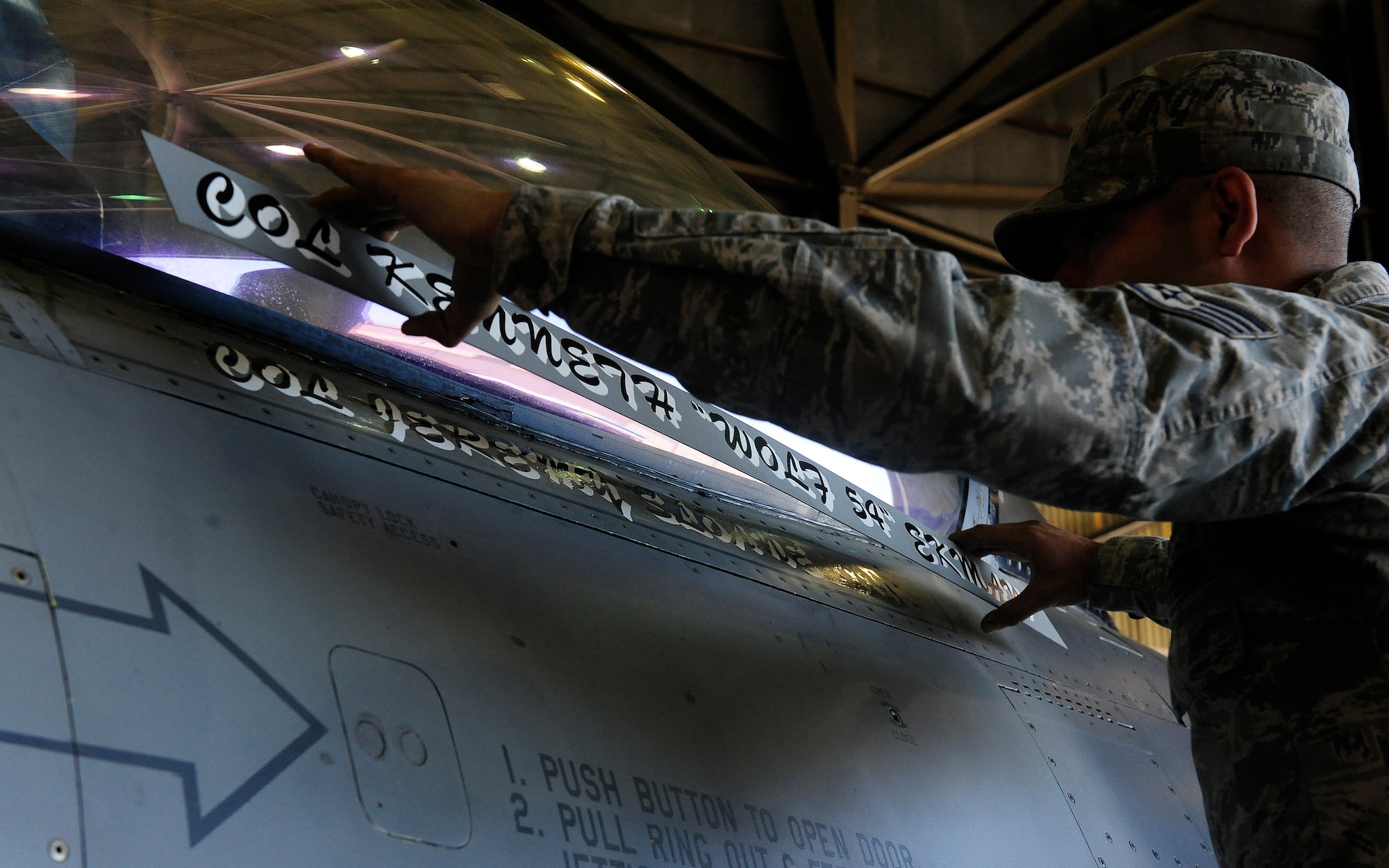 Staff Sgt. Manuel Oros, 35th Aircraft Maintenance Unit F-16 Fighting Falcon crew chief, performs the unveiling of the new 8th Fighter Wing commander’s name on his jet during the 8th Fighter Wing change of command ceremony at Kunsan Air Base, Republic of Korea, May 21, 2015. Col. Jeremy “Wolf” Sloane, 8th FW commander, accepted command from Lt. Gen. Terrence O’Shaughnessy, 7th Air Force and Air Component Command U.S. Forces Korea/U.S. Combined Forces commander.  (U.S. Air Force photo by Staff Sgt. Nick Wilson/Released)