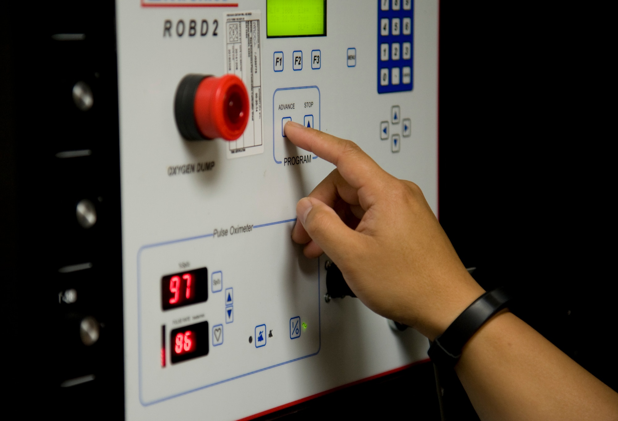 U.S. Air Force Capt. Joseph Teodoro, 35th Operations Support Squadron aircrew flight equipment flight commander, adjusts the amount of oxygen on the reduce oxygen breathing device during hypoxia familiarization training at Misawa Air Base, Japan, May 20, 2015. This system is designed to allow pilots the ability to experience hypoxia, a lack of oxygen reaching the body, in a controlled situation to identify the symptoms it causes. (U.S. Air Force photo by Airman 1st Class Jordyn Fetter/Released)